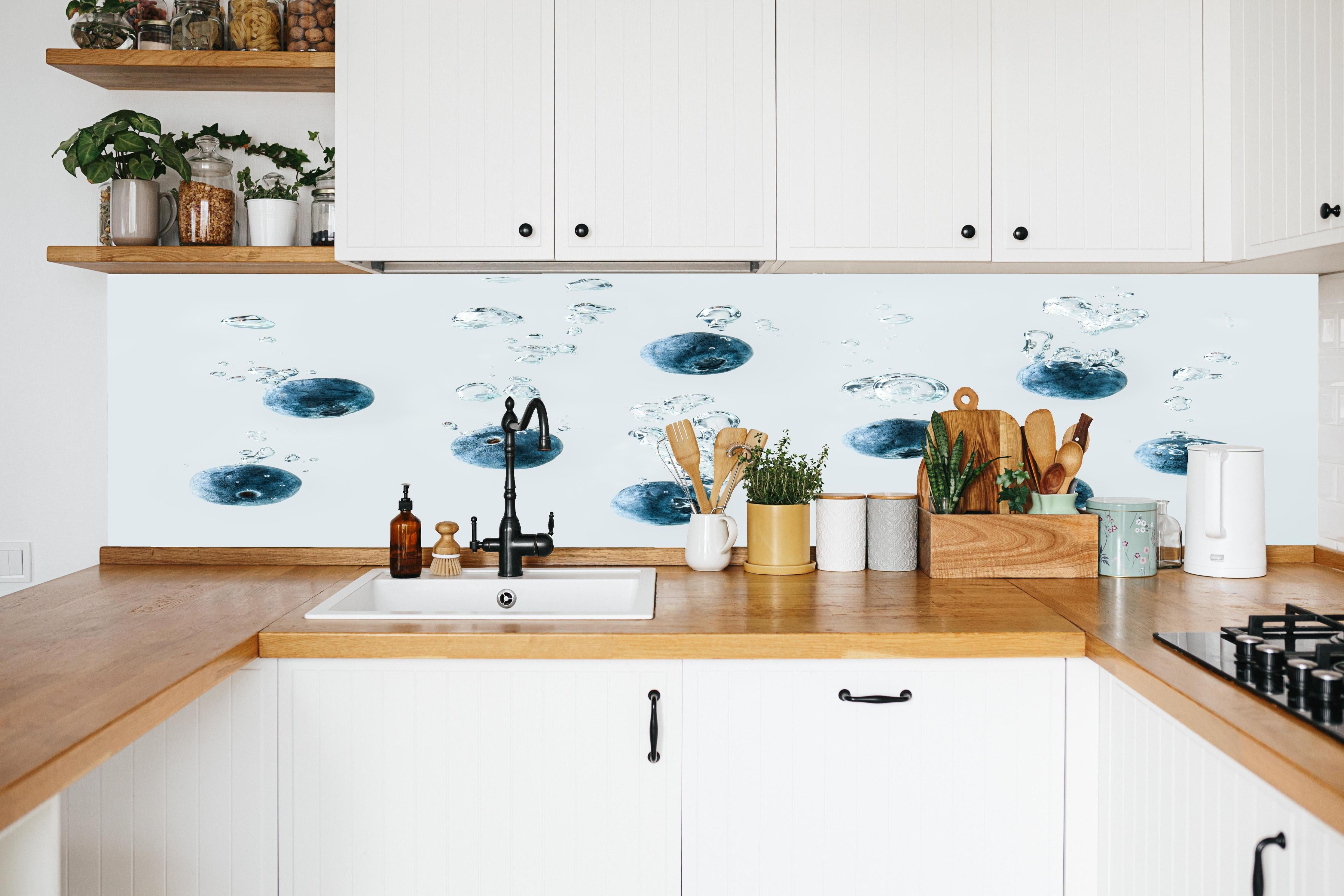 Küche - Blaubeeren im Wassertropfen in weißer Küche hinter Gewürzen und Kochlöffeln aus Holz