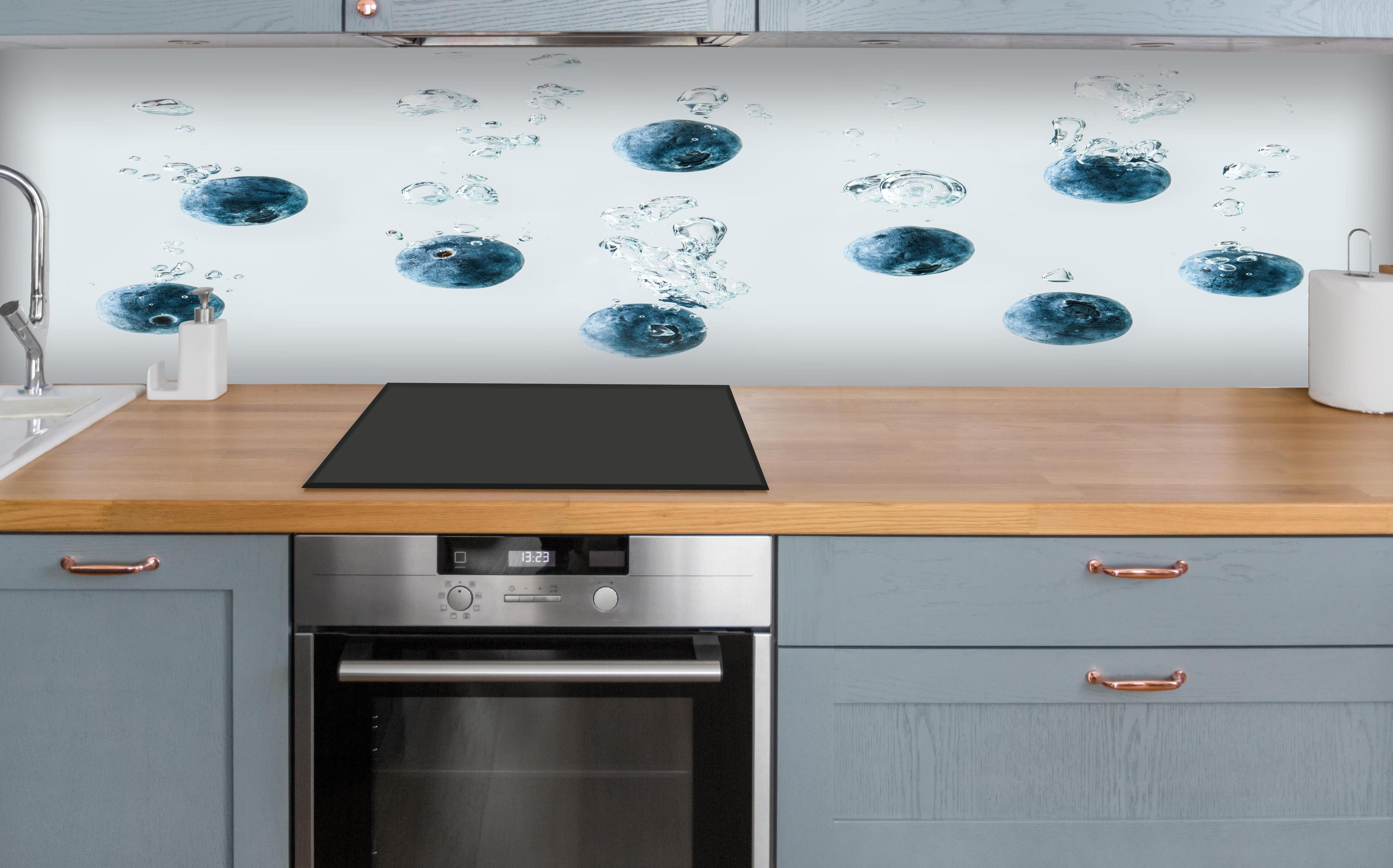 Küche - Blaubeeren im Wassertropfen über polierter Holzarbeitsplatte mit Cerankochfeld