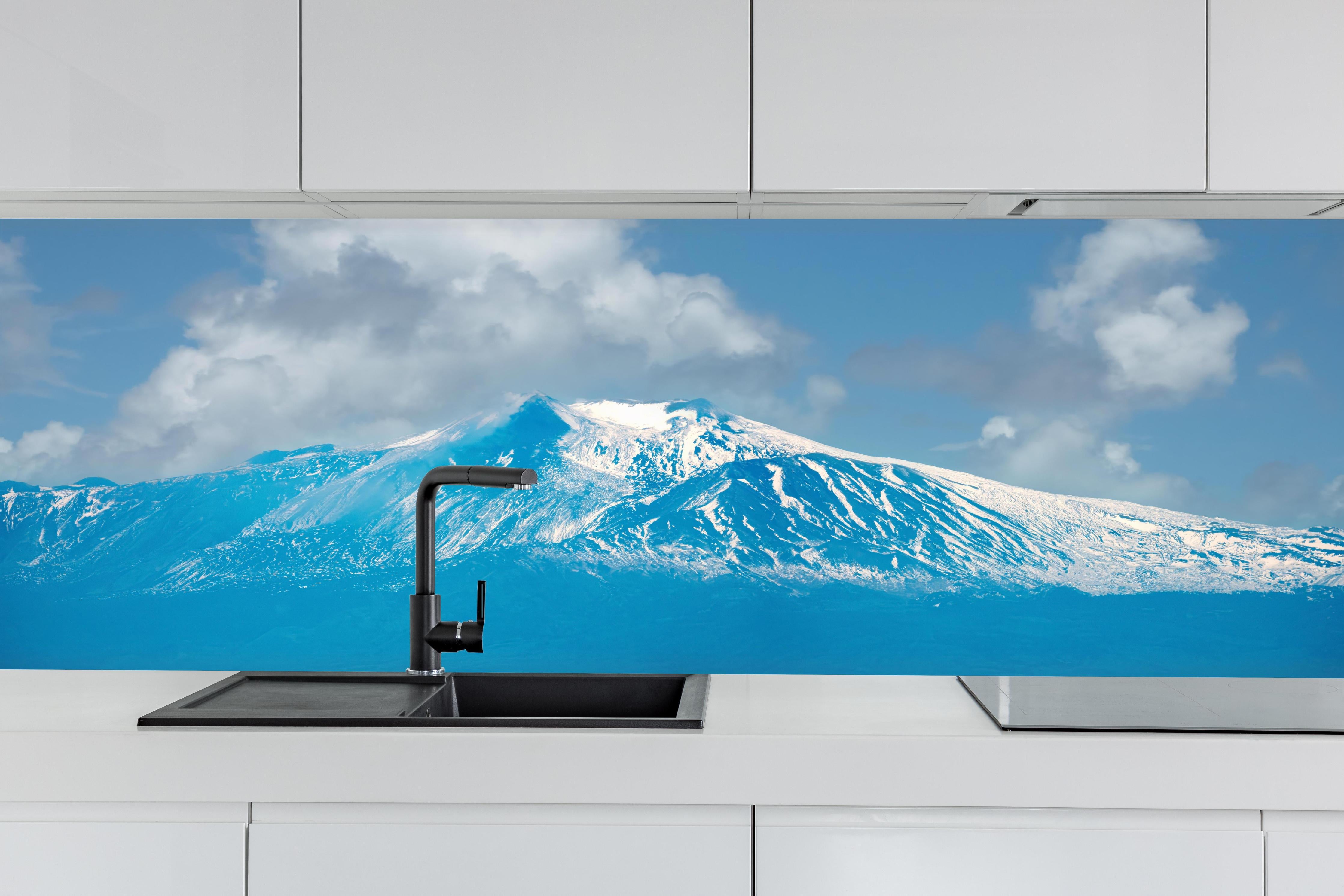 Küche - Blaue Schnee-Berglandschaft hinter weißen Hochglanz-Küchenregalen und schwarzem Wasserhahn