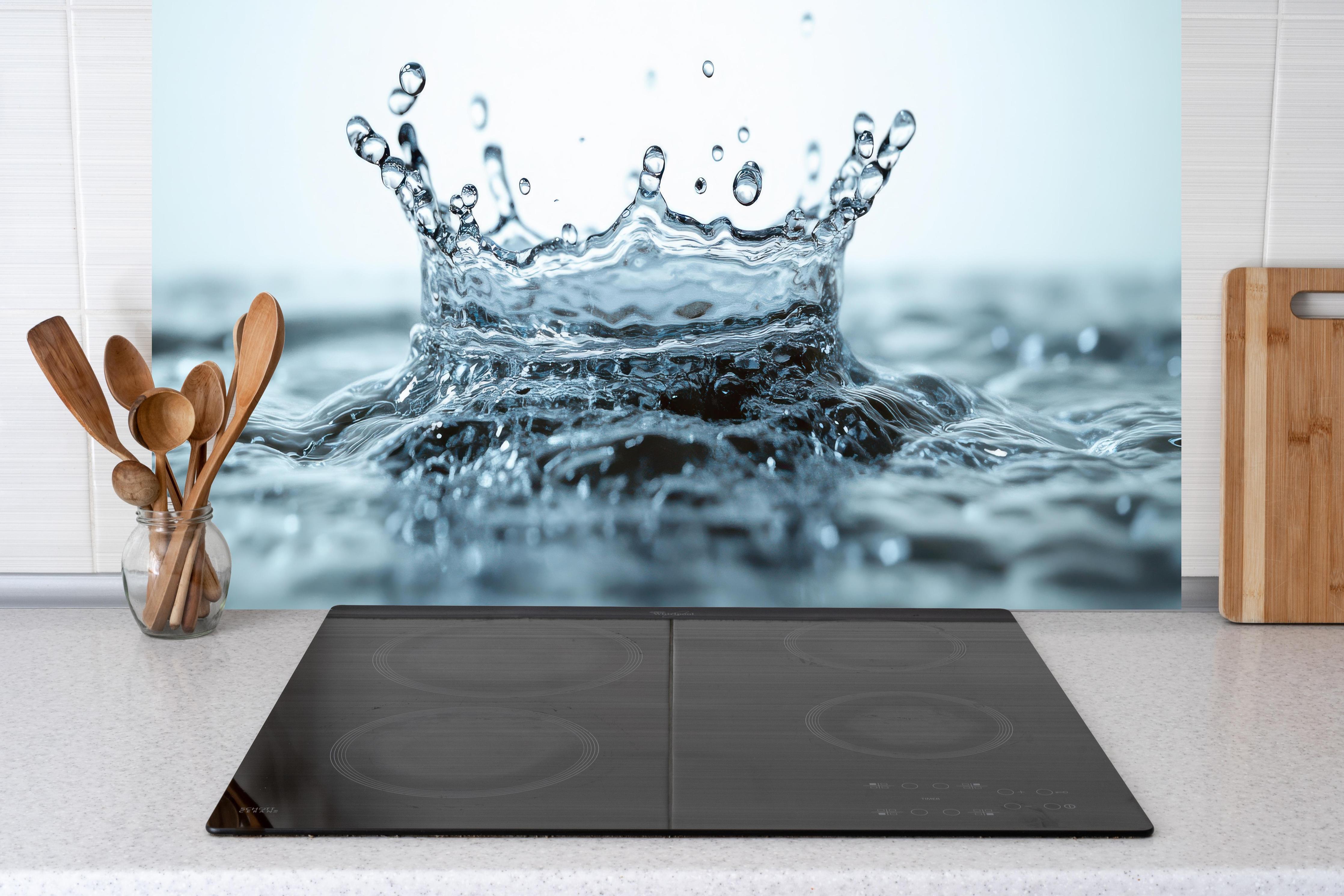 Küche - Blauer Wasser-Splash hinter Cerankochfeld und Holz-Kochutensilien