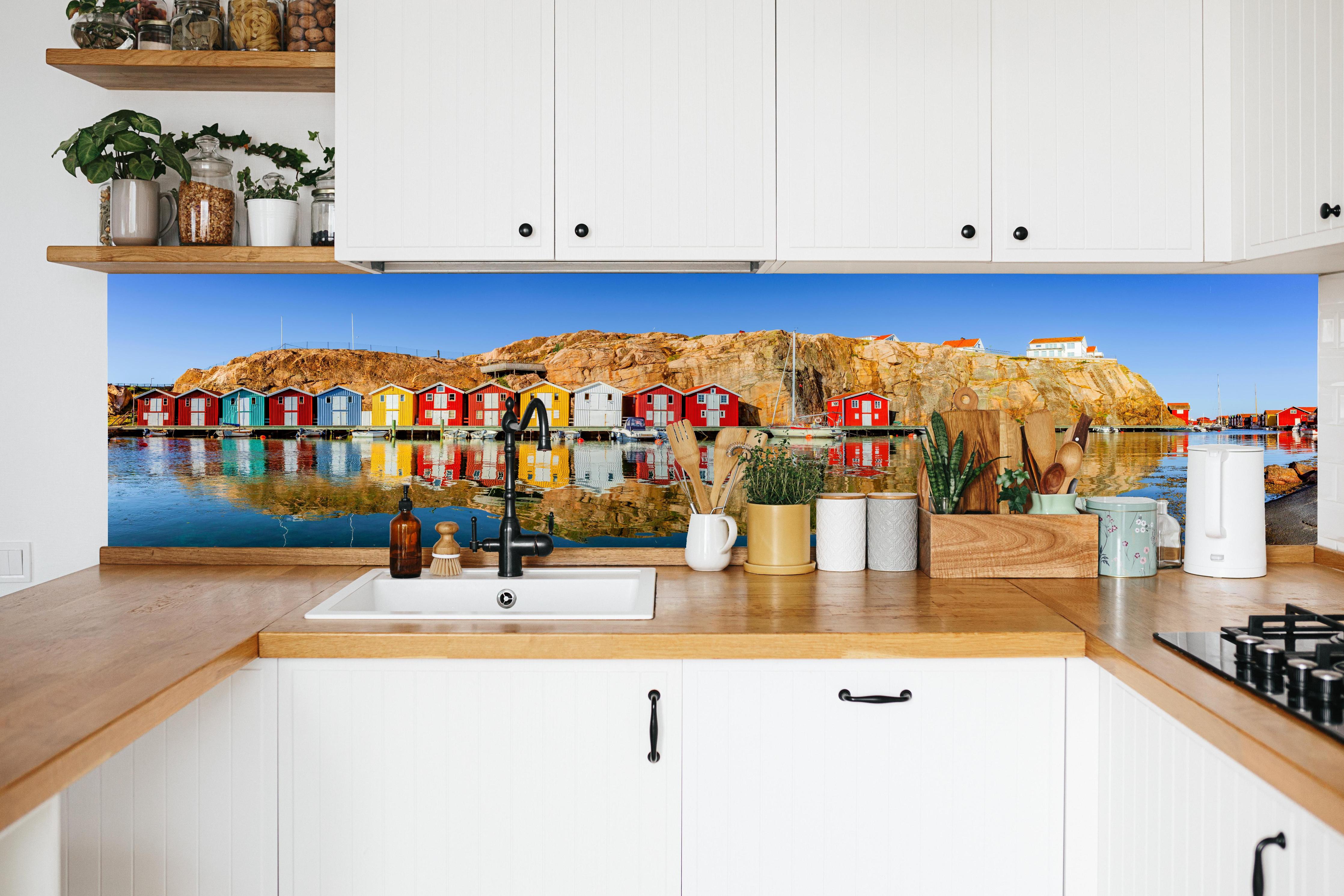 Küche - Bunte Fischerhäuser in Schweden in weißer Küche hinter Gewürzen und Kochlöffeln aus Holz