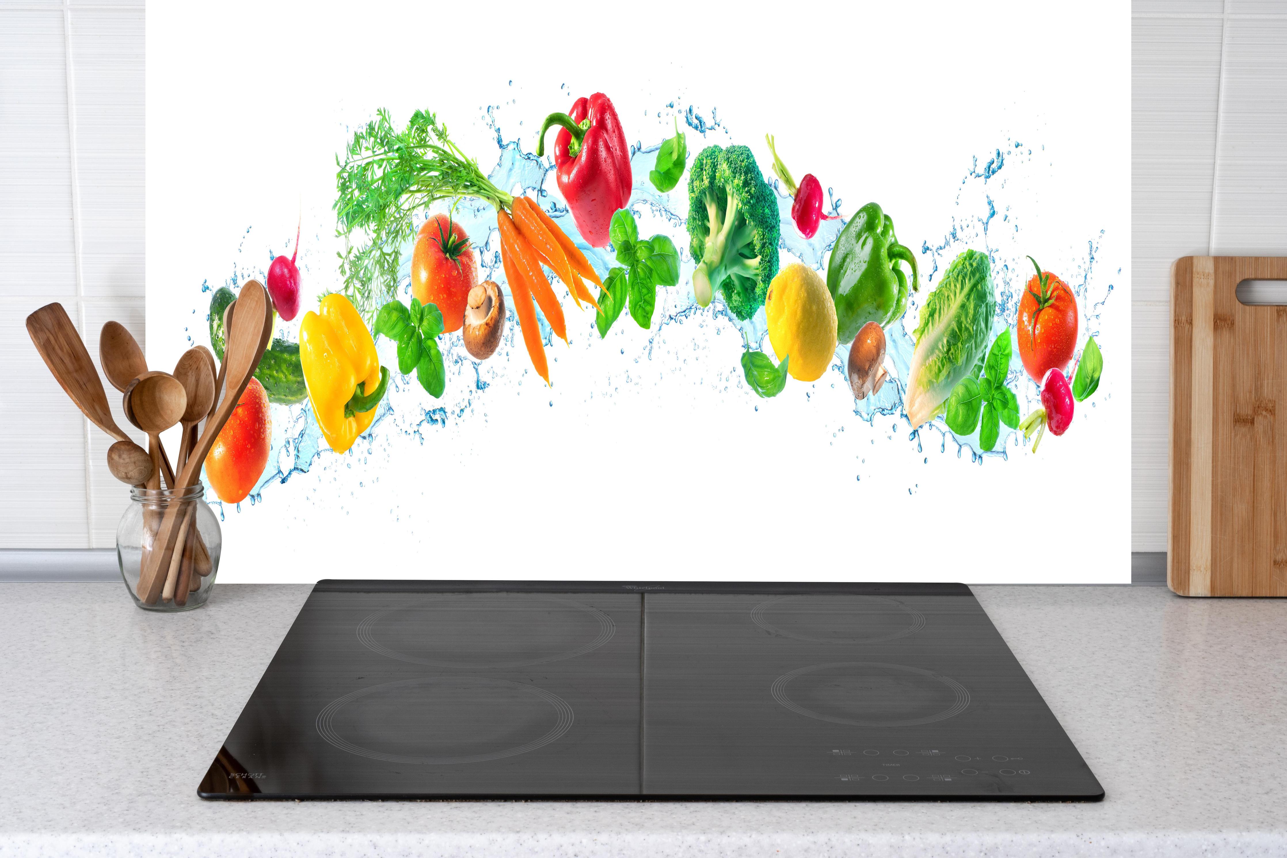 Küche - Bunte Gemüse- und Kräuterkomposition hinter Cerankochfeld und Holz-Kochutensilien