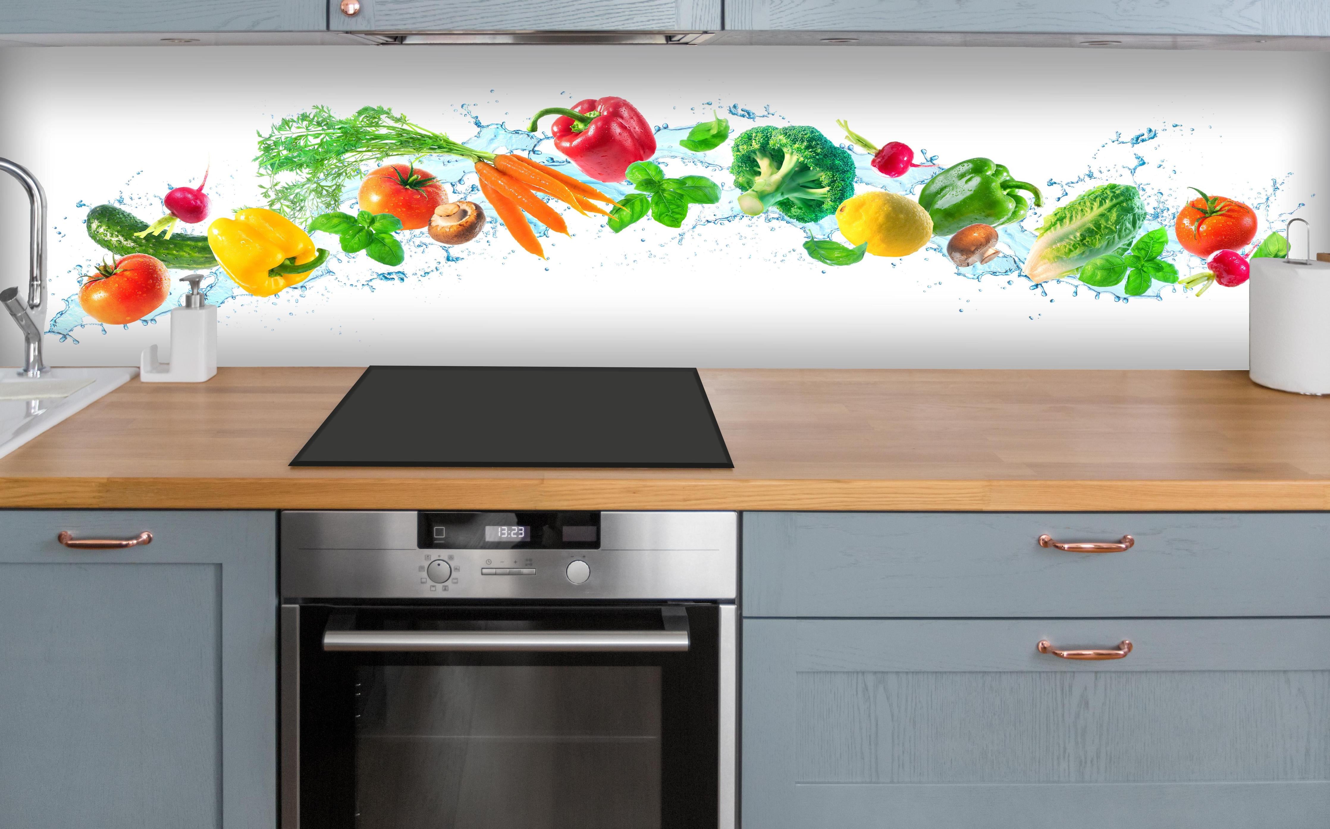 Küche - Bunte Gemüse- und Kräuterkomposition über polierter Holzarbeitsplatte mit Cerankochfeld