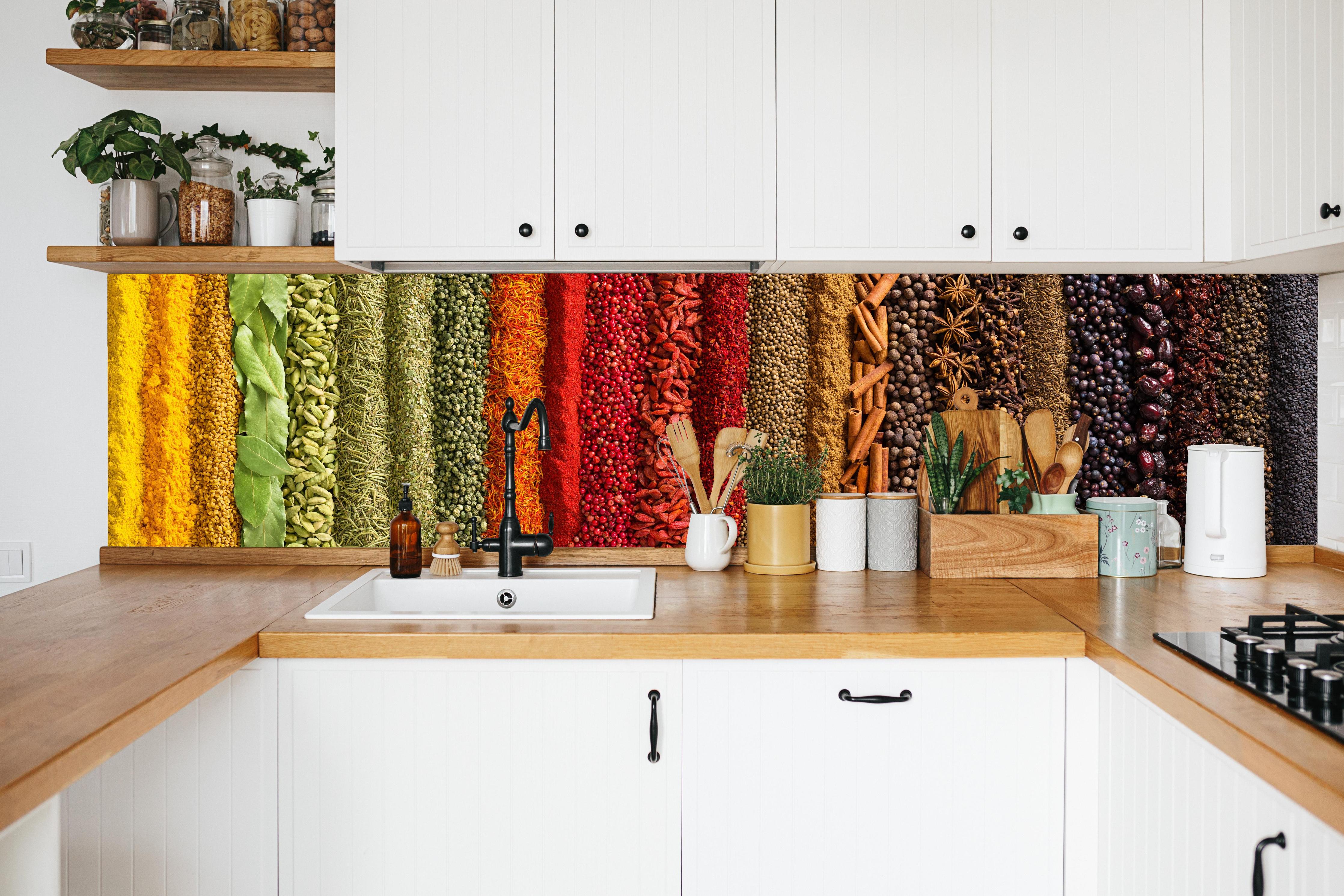 Küche - Bunte Gewürzstreifen in weißer Küche hinter Gewürzen und Kochlöffeln aus Holz
