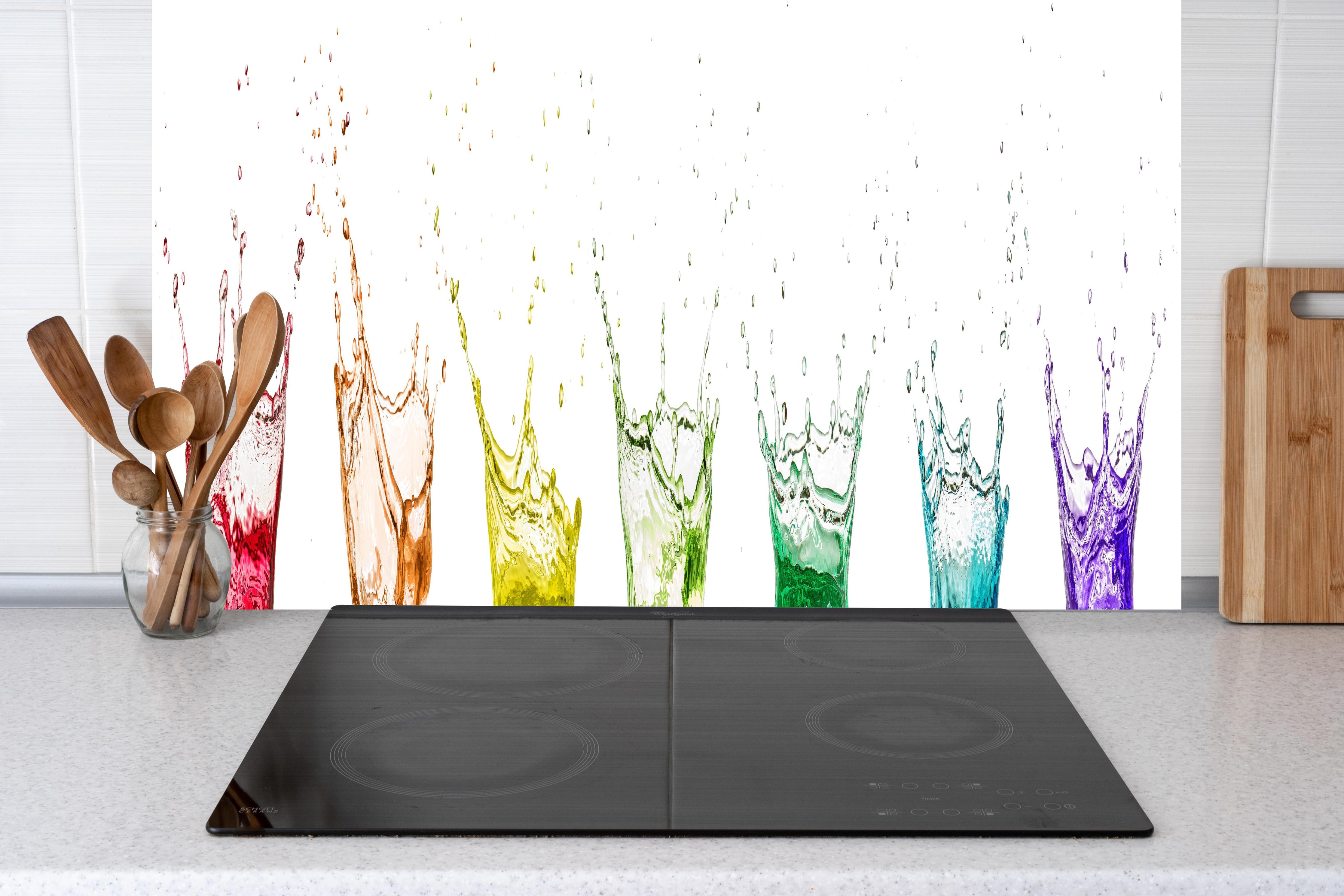 Küche - Bunte Wasserspritzer hinter Cerankochfeld und Holz-Kochutensilien