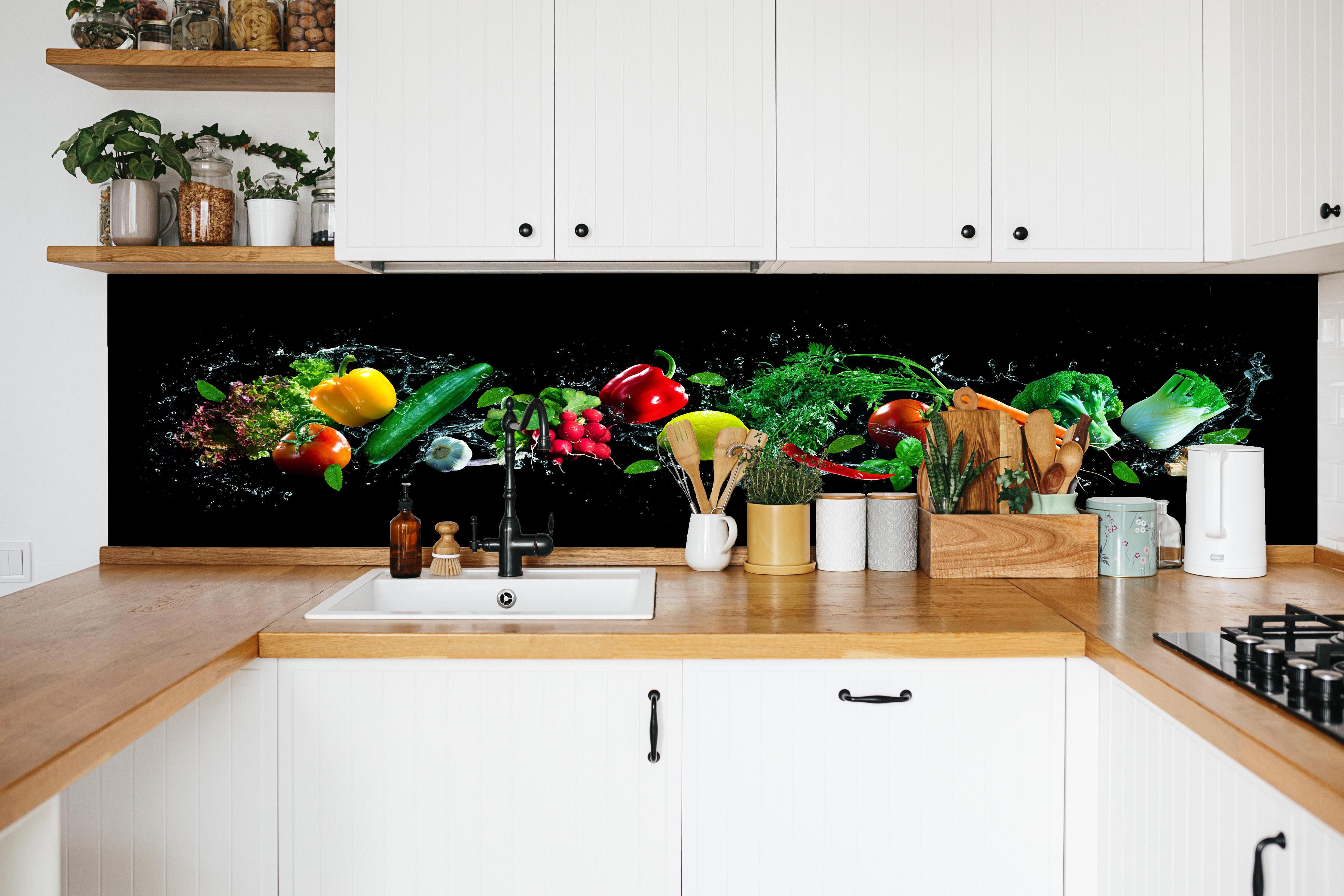 Küche - Buntes Obst auf schwarzem Hintergrund in weißer Küche hinter Gewürzen und Kochlöffeln aus Holz