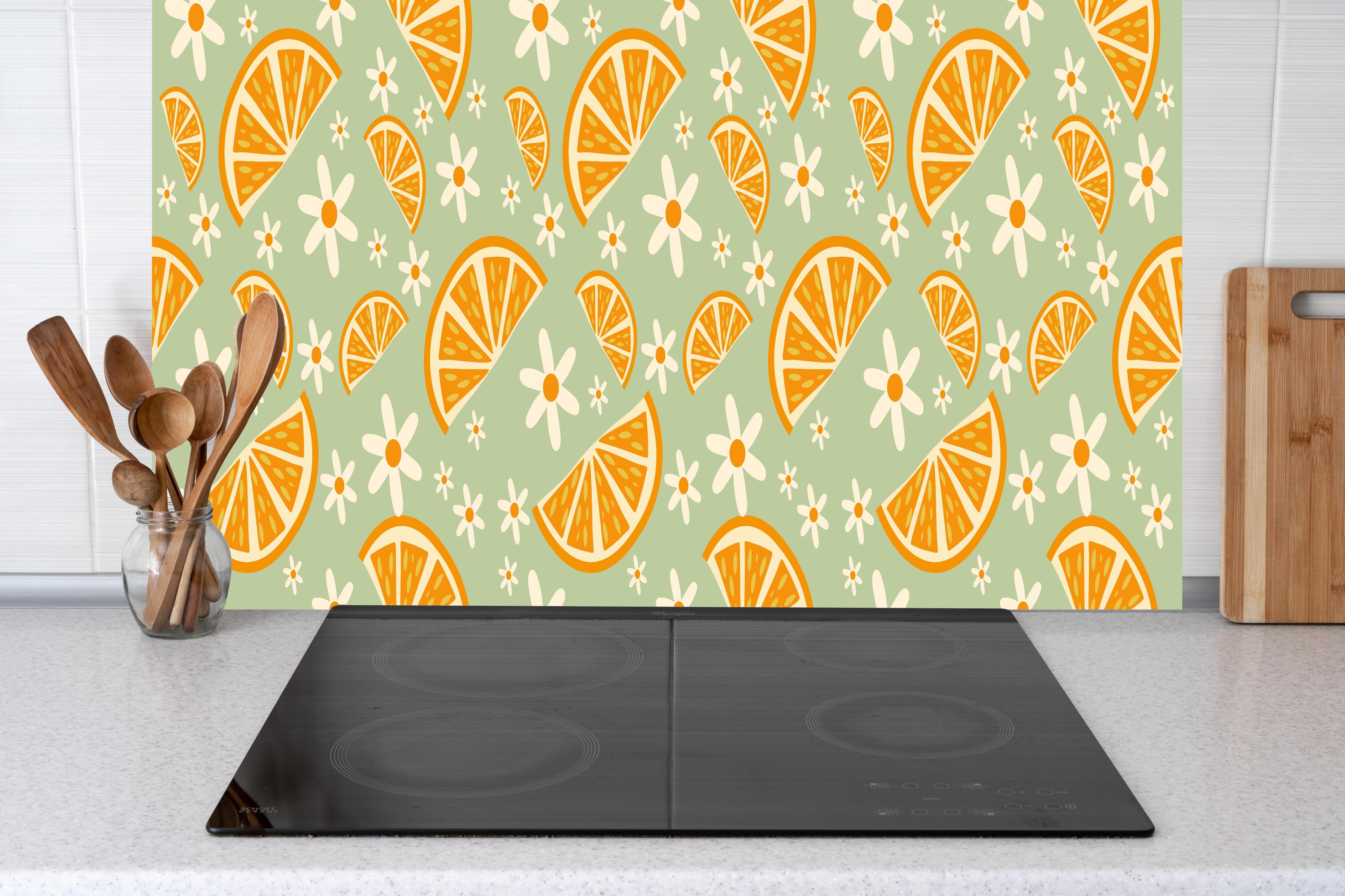 Küche - Citrus-Orangenmuster in Mint hinter Cerankochfeld und Holz-Kochutensilien