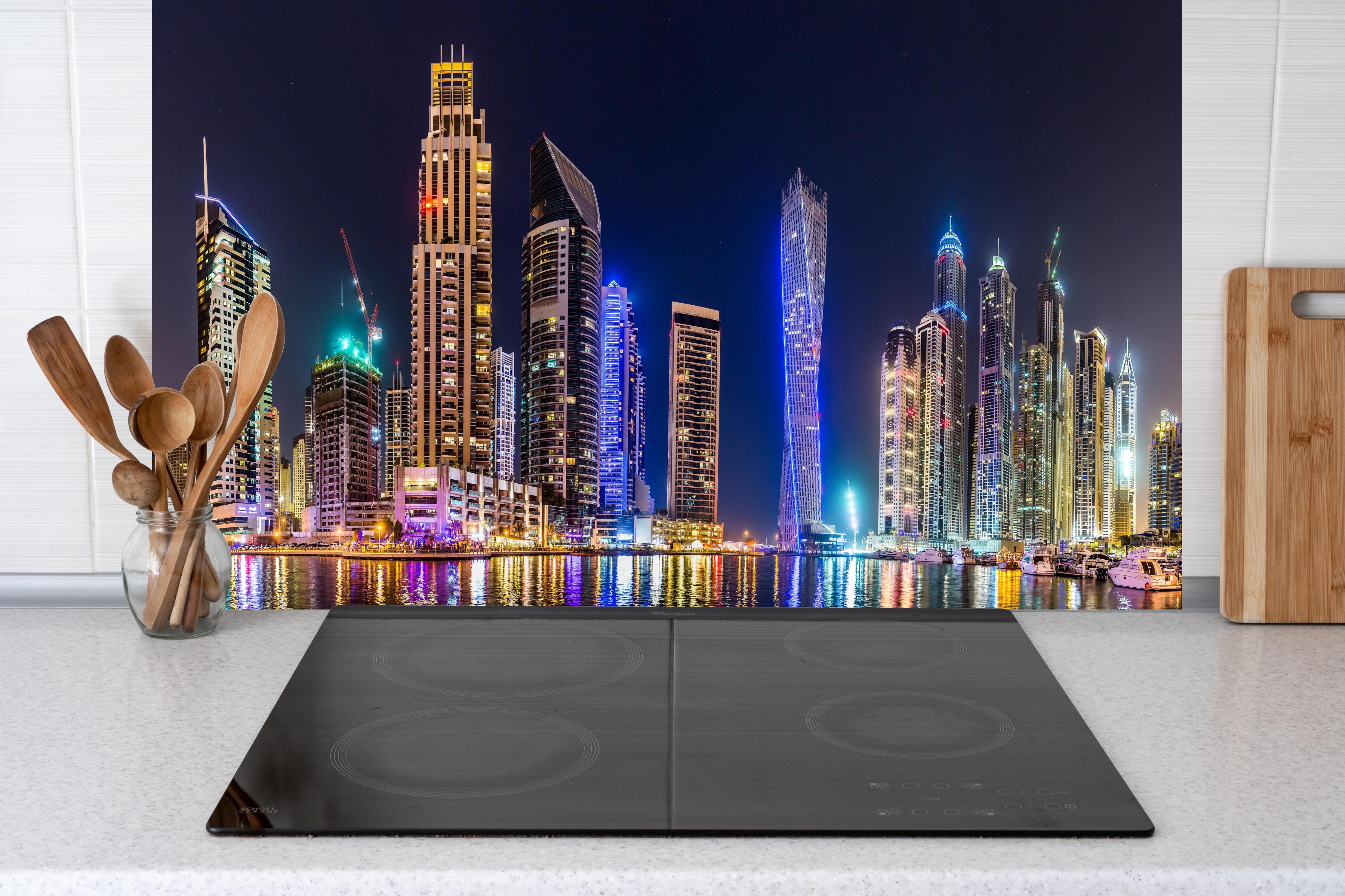 Küche - Dubai Marina Skyline bei Nacht hinter Cerankochfeld und Holz-Kochutensilien