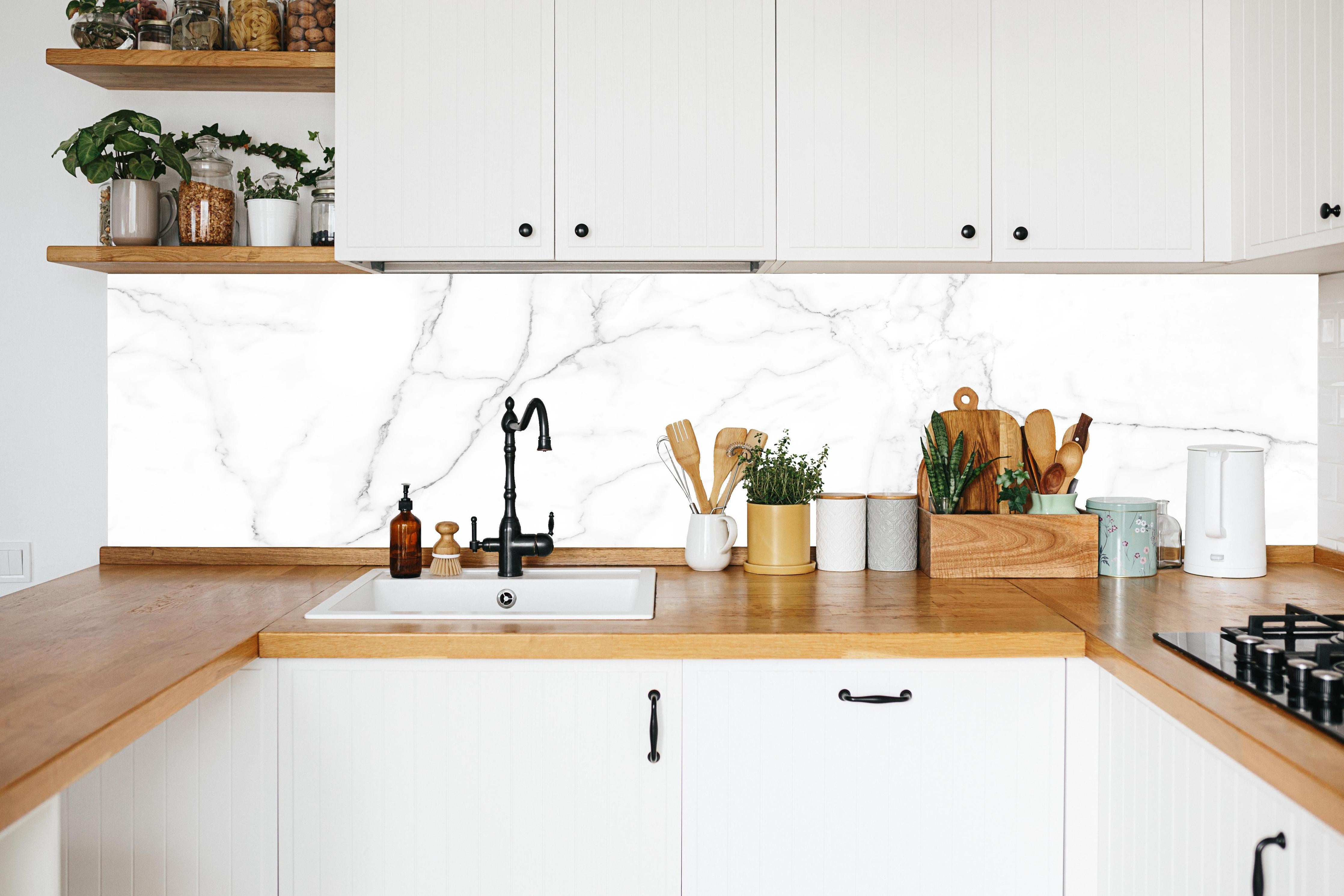 Küche - Edle Marmor-Textur im Luxus-Stil in weißer Küche hinter Gewürzen und Kochlöffeln aus Holz