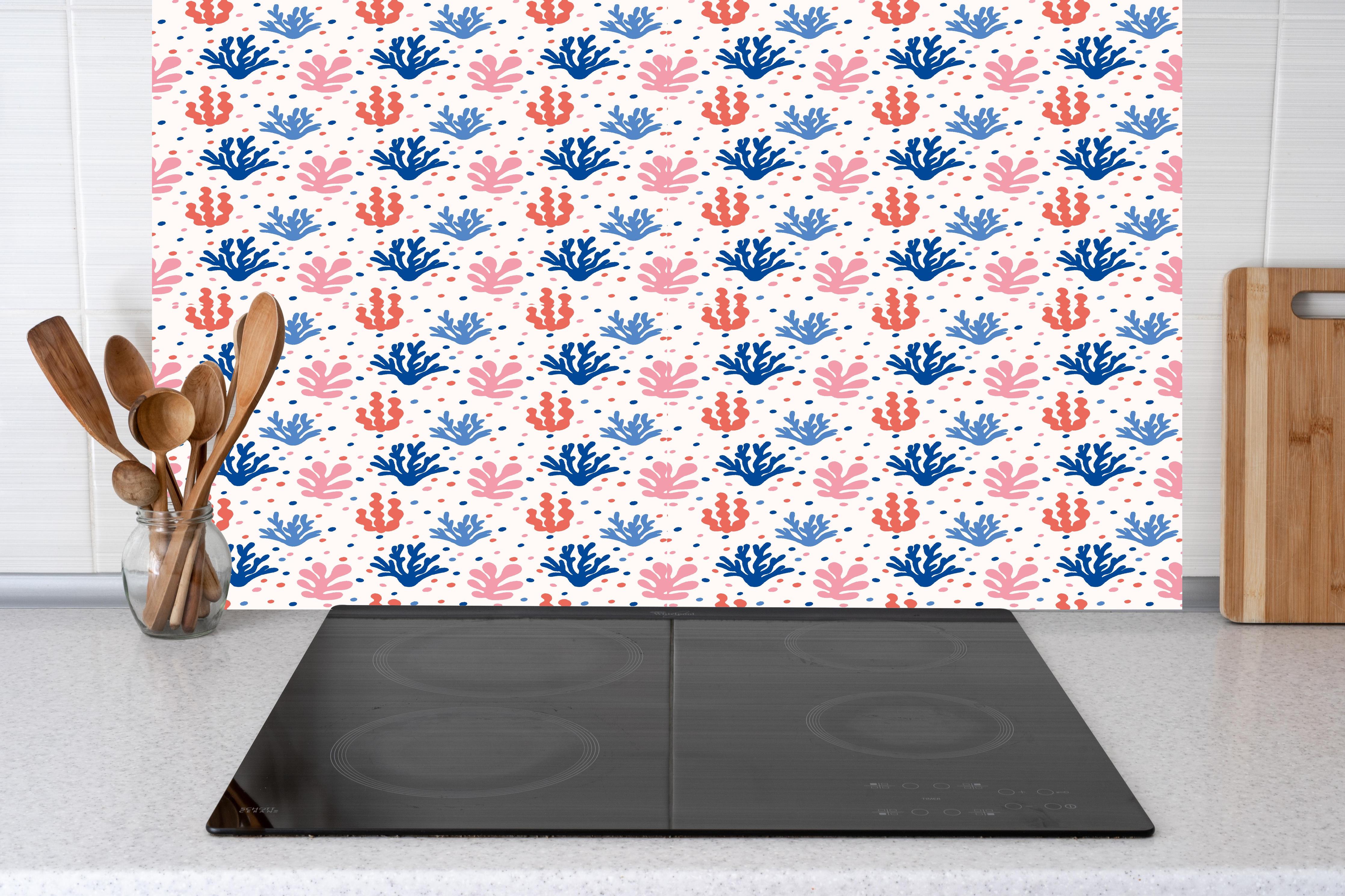 Küche - Exotisches Korallen-Design in Blau und Rosa hinter Cerankochfeld und Holz-Kochutensilien