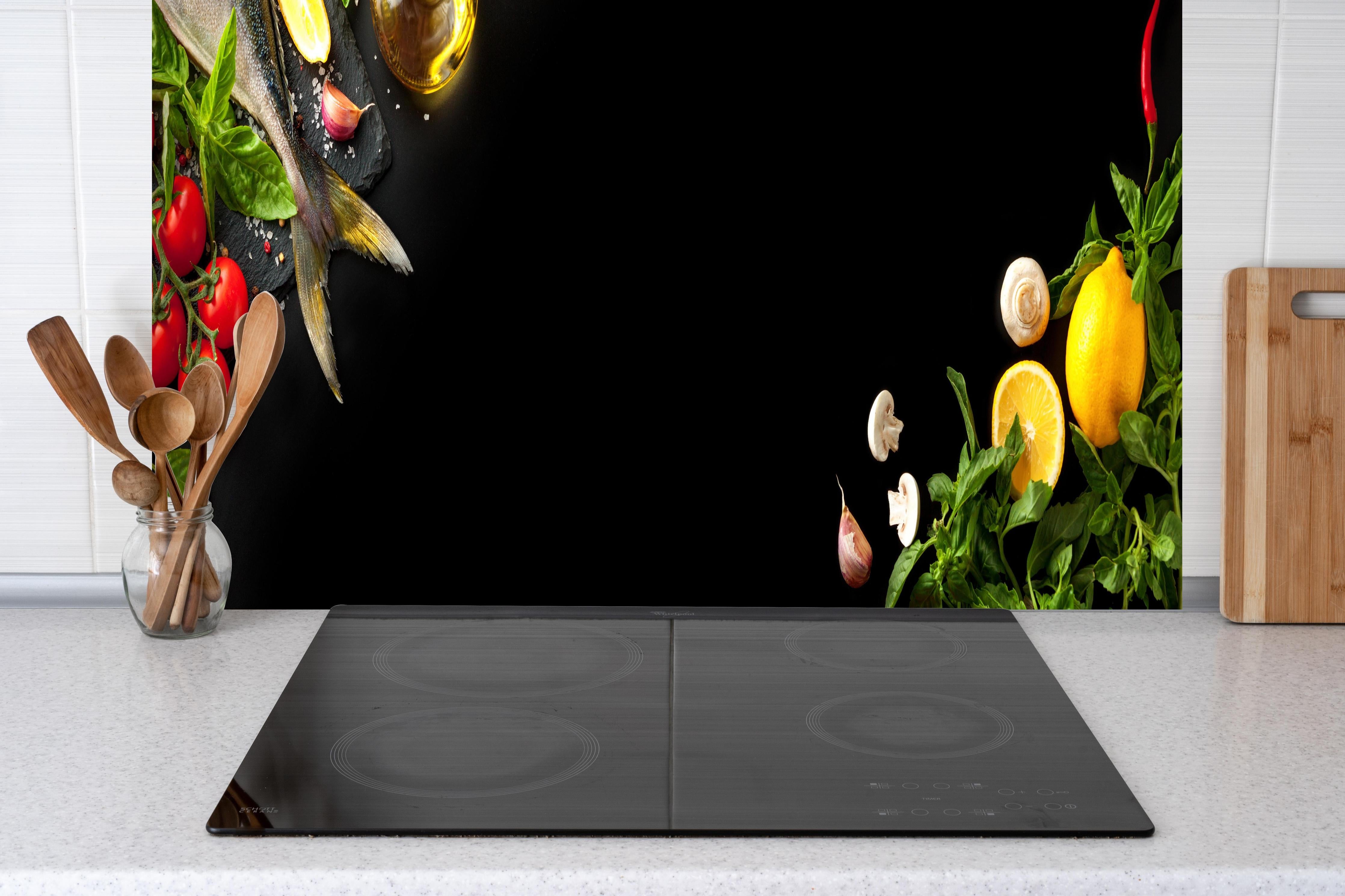 Küche - Fischzutaten auf schwarzem Hintergrund hinter Cerankochfeld und Holz-Kochutensilien