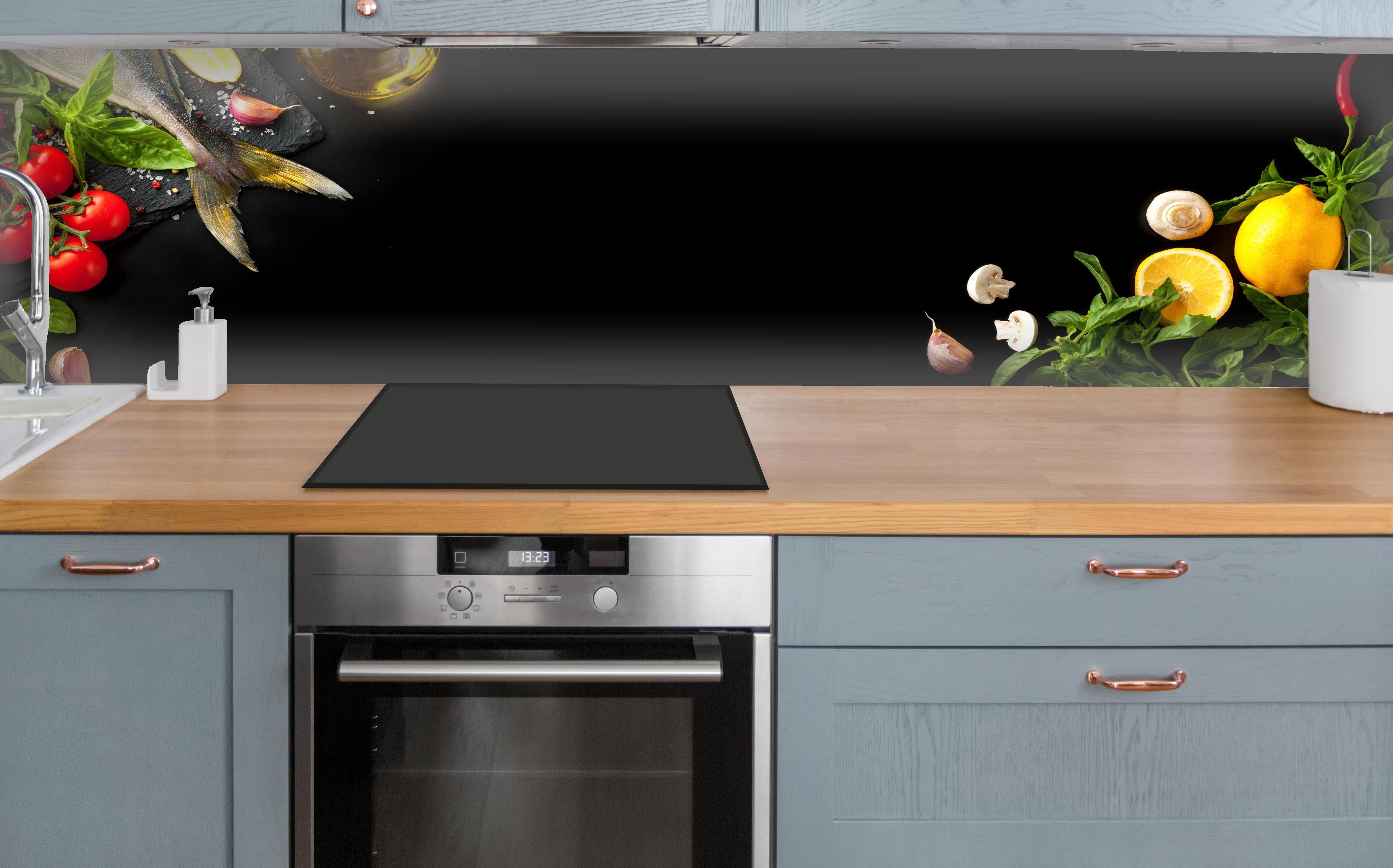 Küche - Fischzutaten auf schwarzem Hintergrund über polierter Holzarbeitsplatte mit Cerankochfeld