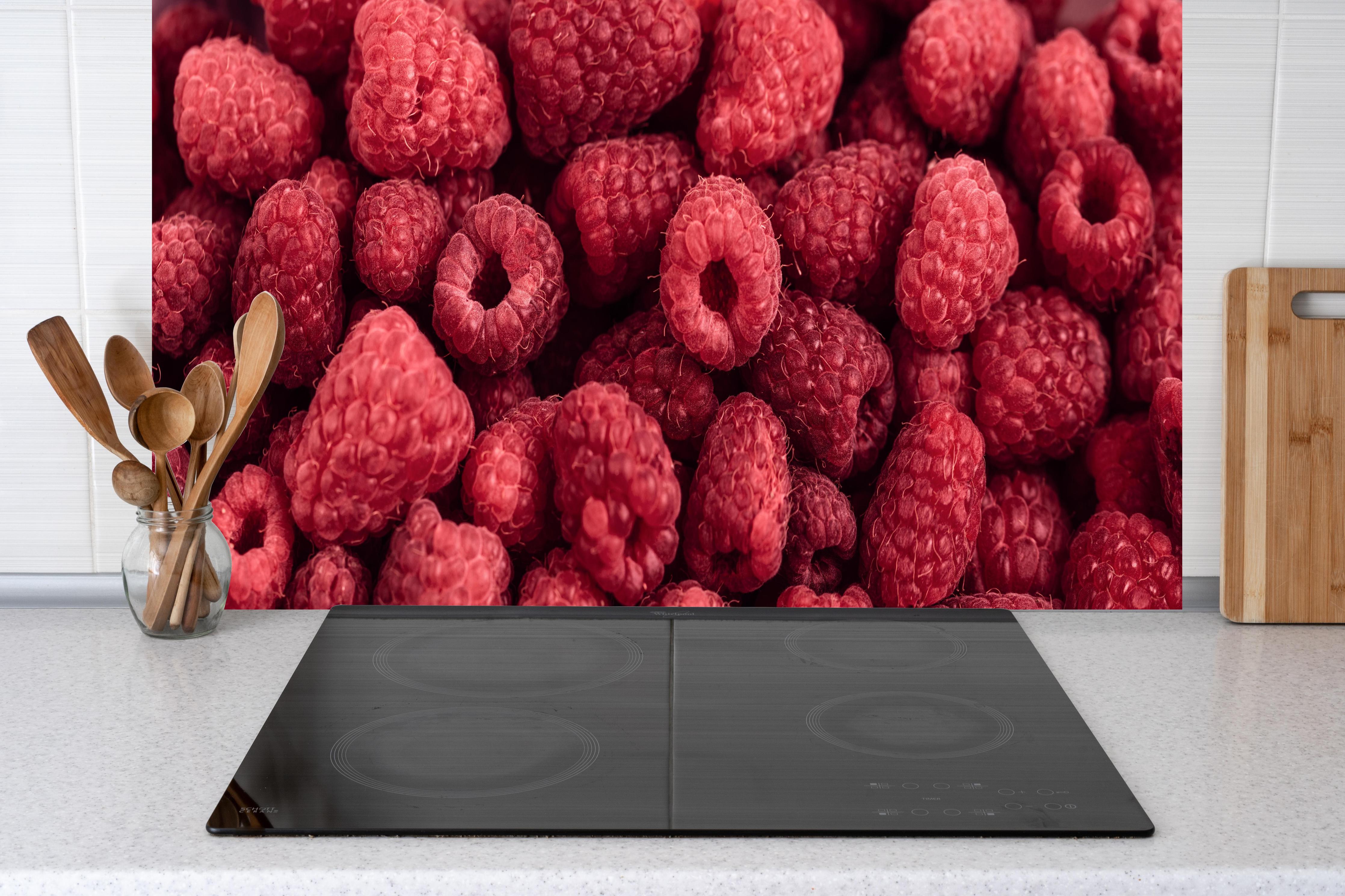 Küche - Frische Himbeer-Textur Rot hinter Cerankochfeld und Holz-Kochutensilien