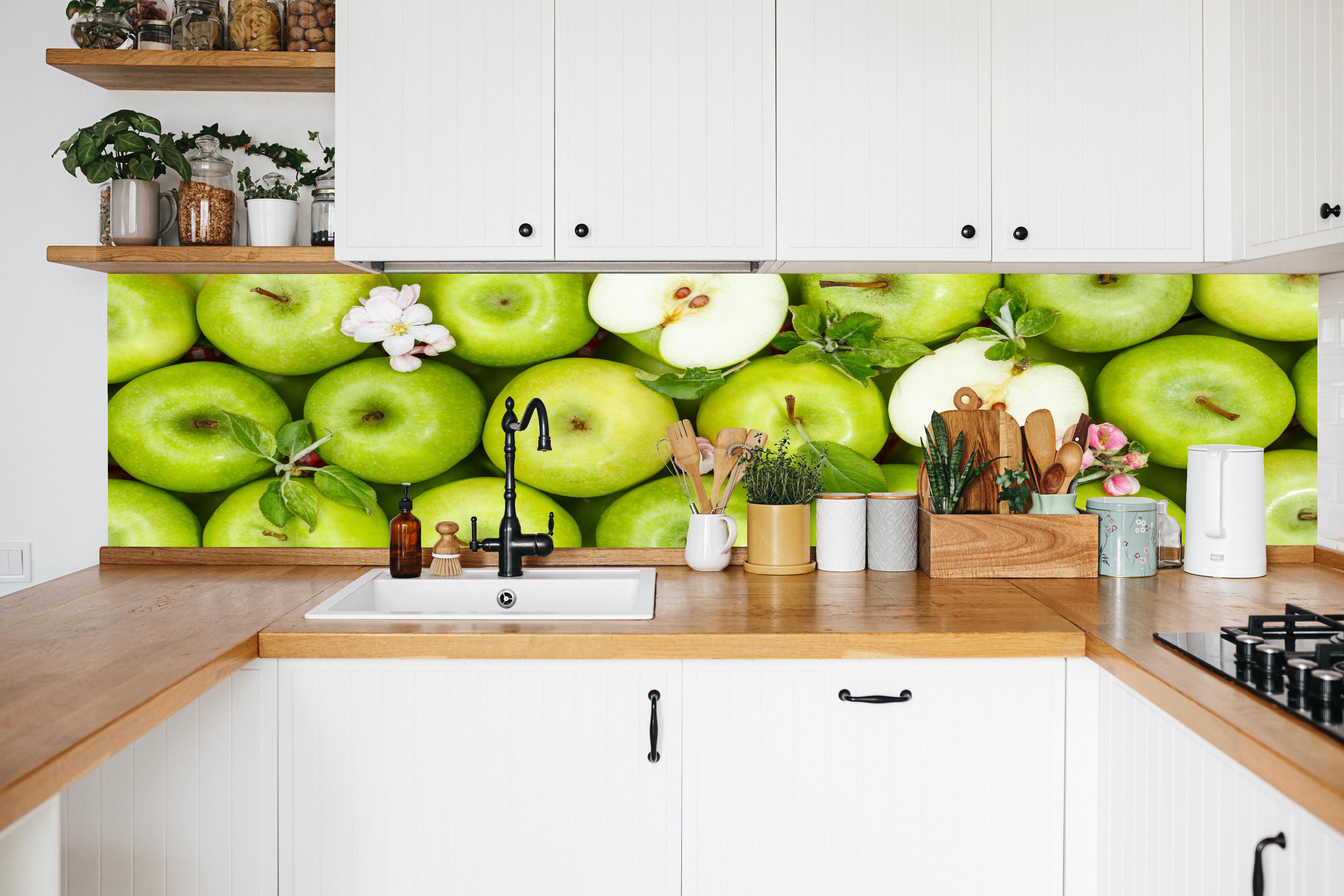 Küche - Frische grüne Äpfel in weißer Küche hinter Gewürzen und Kochlöffeln aus Holz