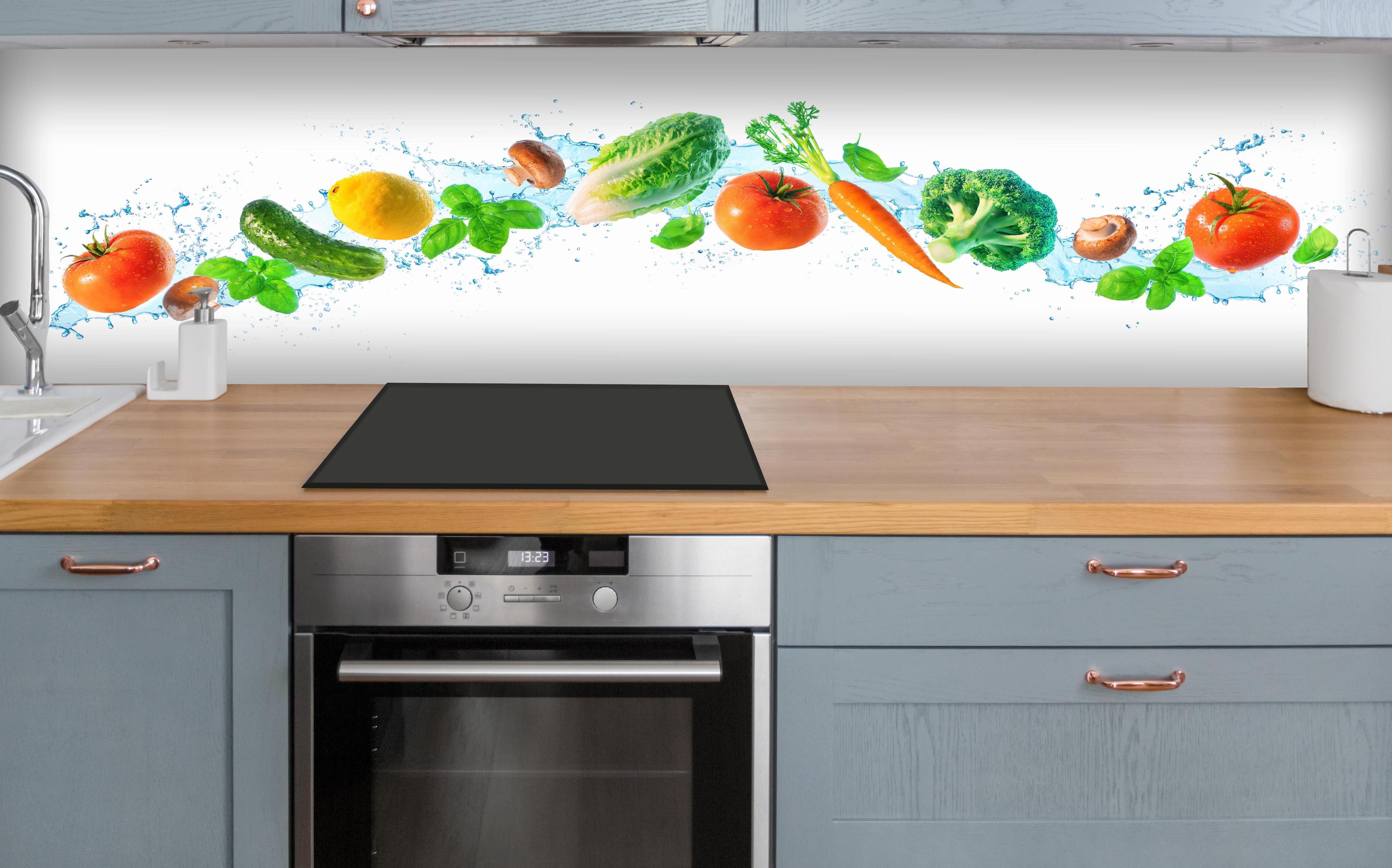 Küche - Frischer Gemüse-Splash Weiß über polierter Holzarbeitsplatte mit Cerankochfeld