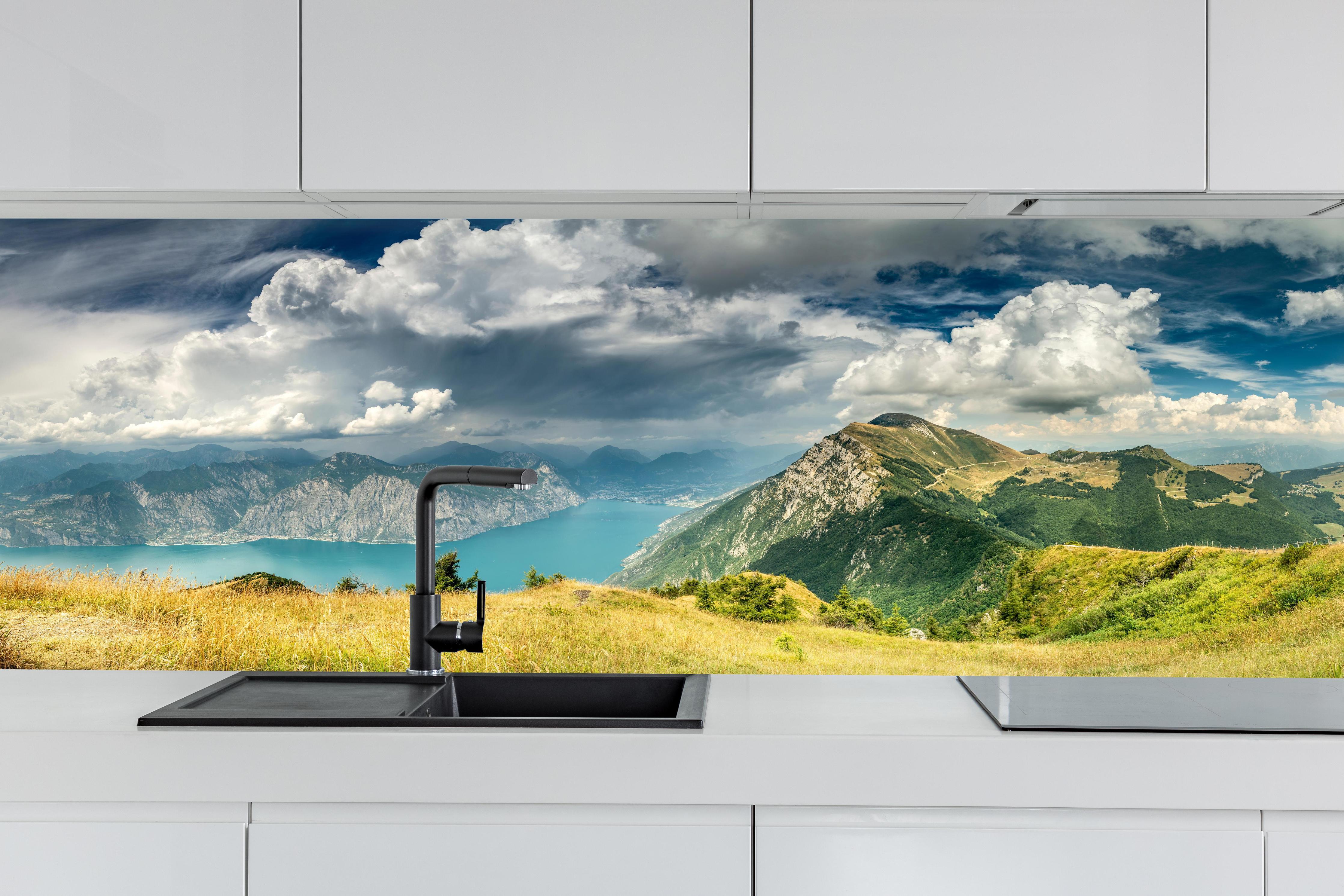 Küche - Gardasee – Harmonie in Blau-Grün hinter weißen Hochglanz-Küchenregalen und schwarzem Wasserhahn