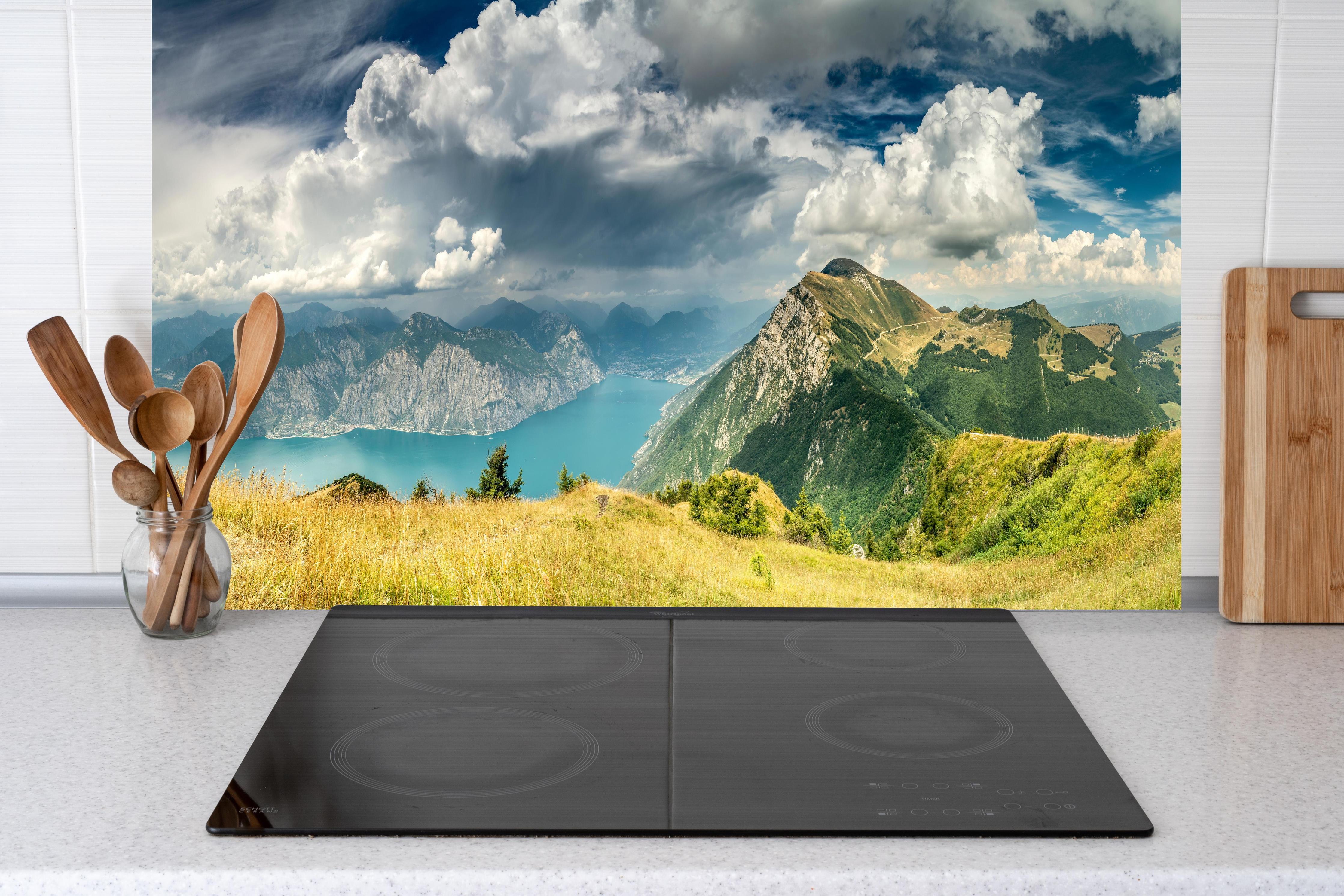Küche - Gardasee – Harmonie in Blau-Grün hinter Cerankochfeld und Holz-Kochutensilien