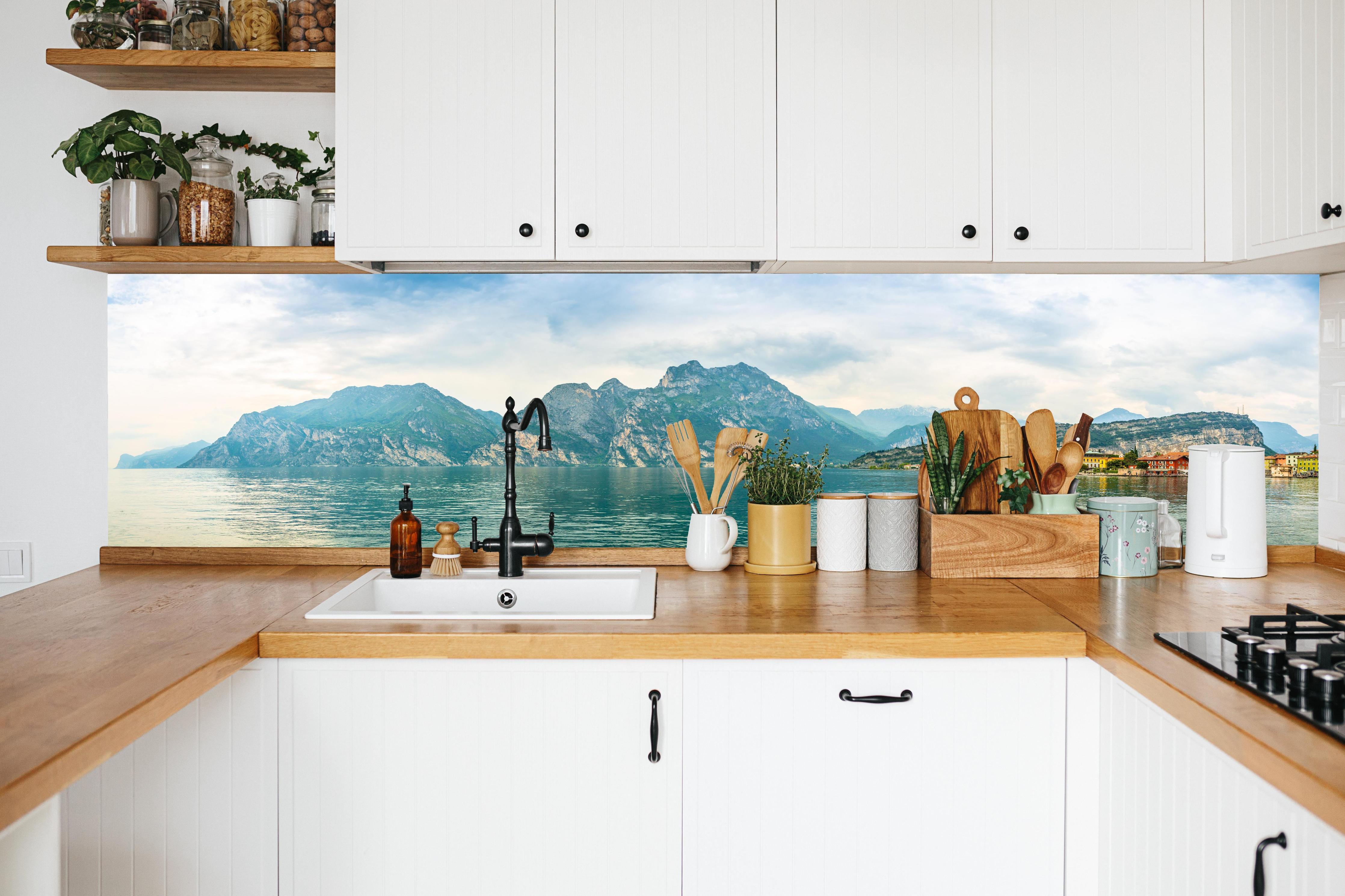 Küche - Gardasee im Farbenspiel von Himmel und Natur in weißer Küche hinter Gewürzen und Kochlöffeln aus Holz