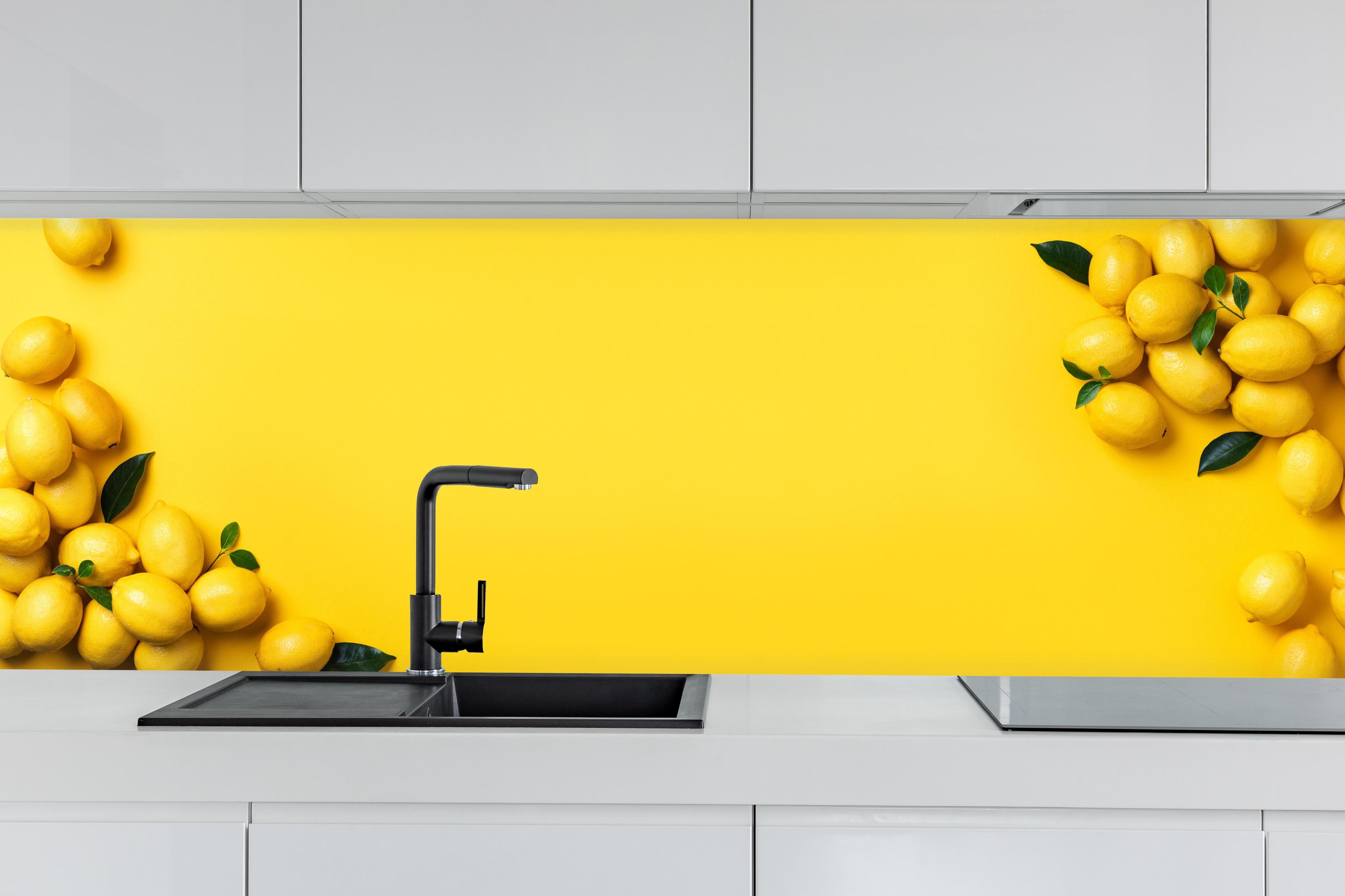 Küche - Gelbe Zitronen & Limetten hinter weißen Hochglanz-Küchenregalen und schwarzem Wasserhahn