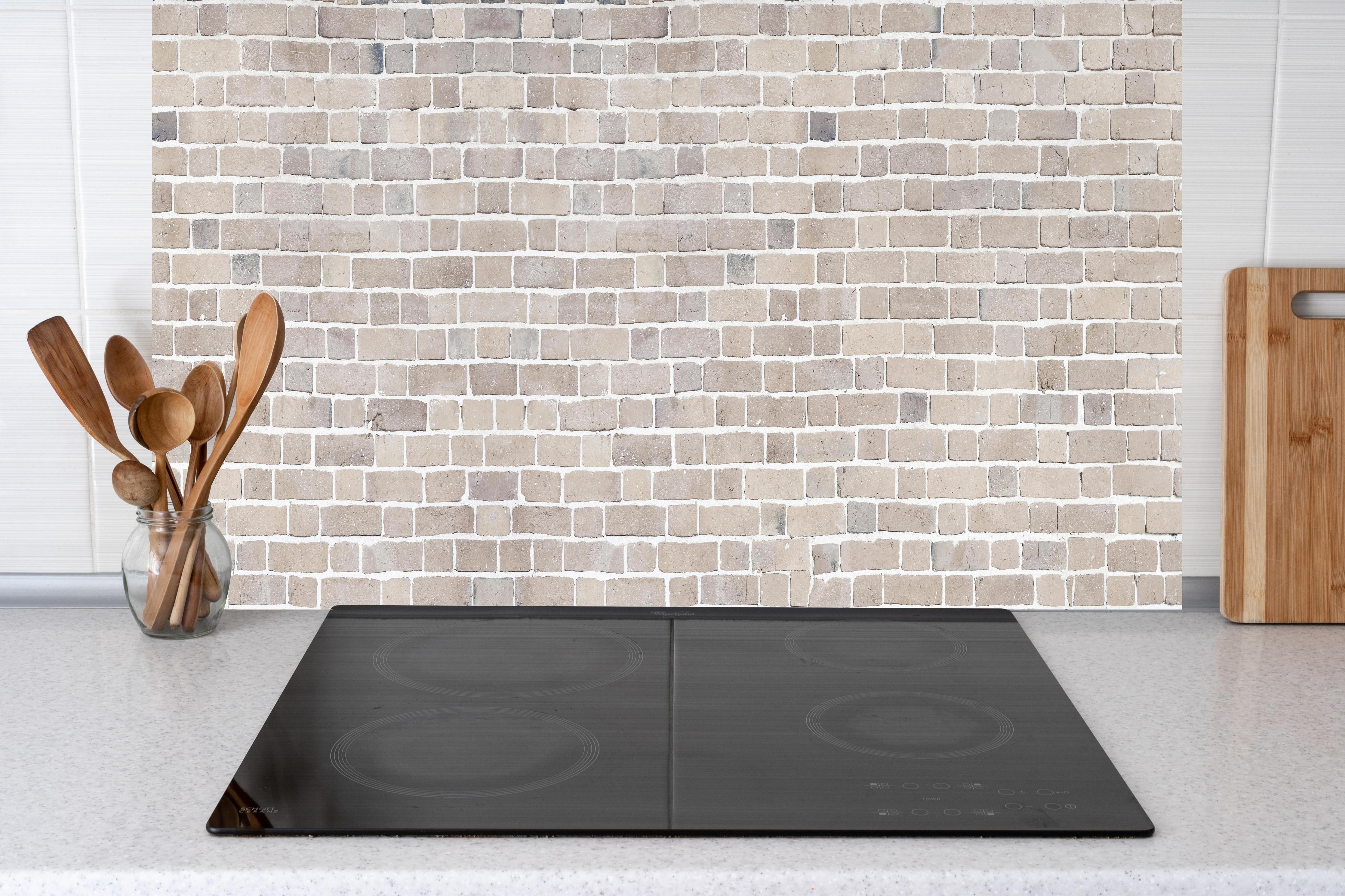 Küche - Helle Beige-Grau Ziegelstruktur hinter Cerankochfeld und Holz-Kochutensilien