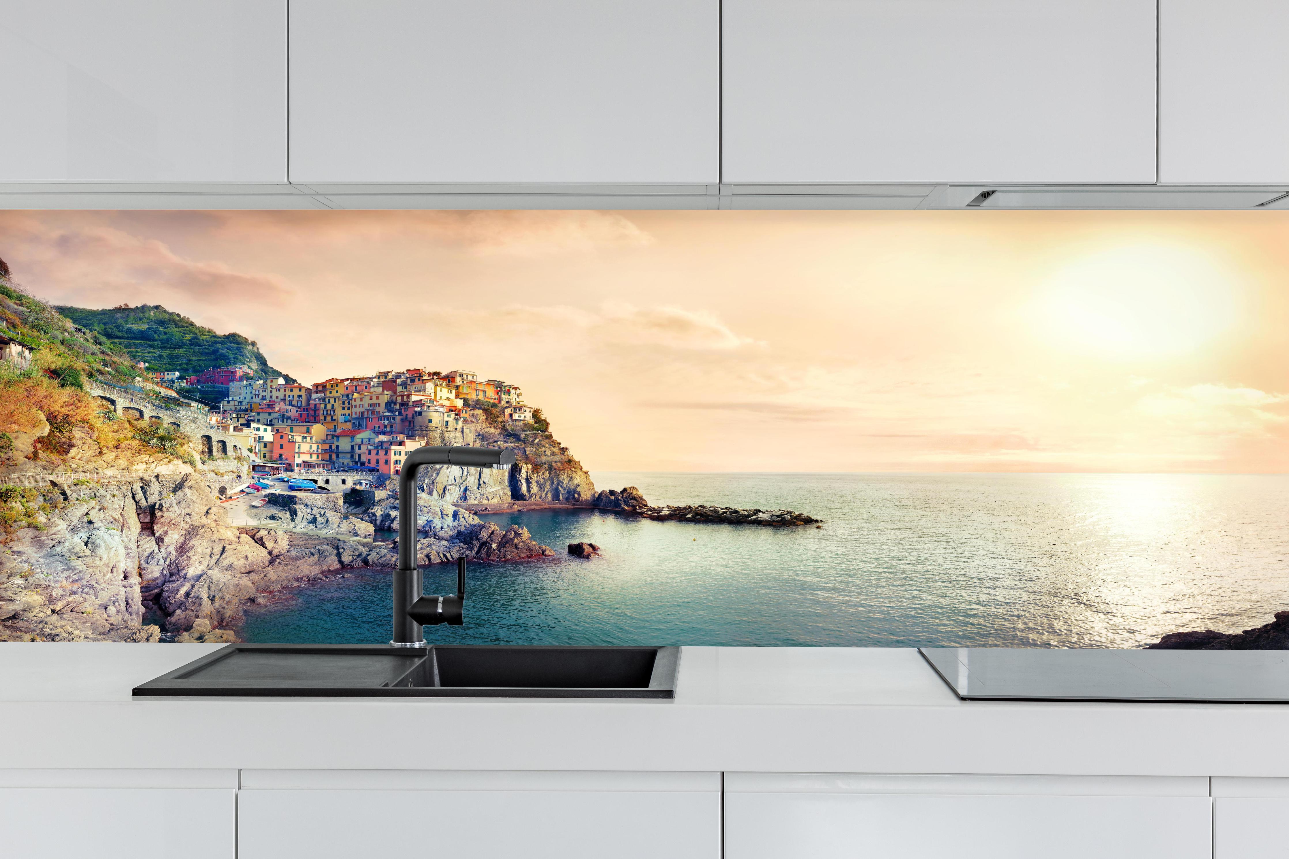 Küche - Italienische Küste Sonnenuntergang hinter weißen Hochglanz-Küchenregalen und schwarzem Wasserhahn