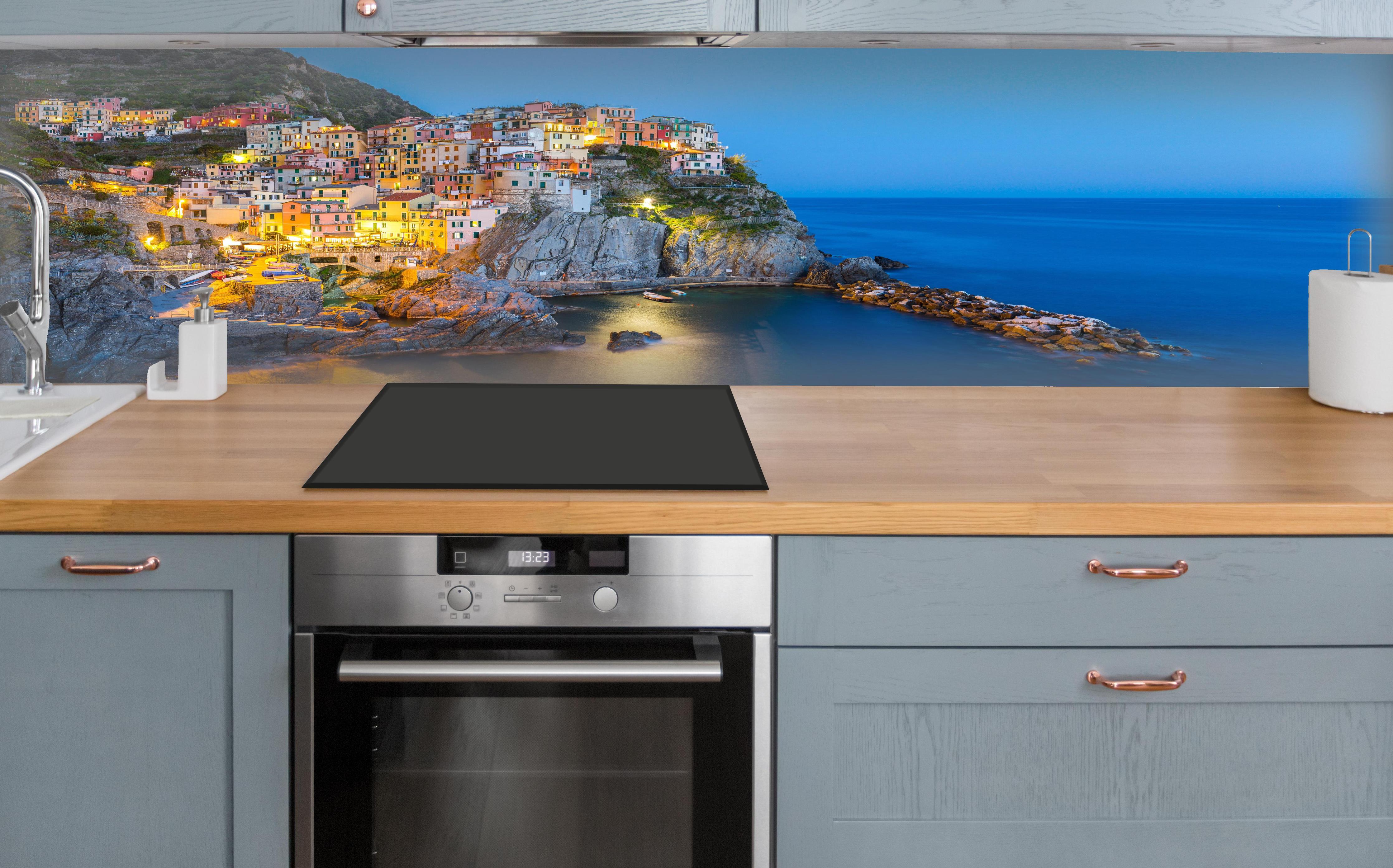 Küche - Italienische Küstenstadt bei Abendlicht über polierter Holzarbeitsplatte mit Cerankochfeld