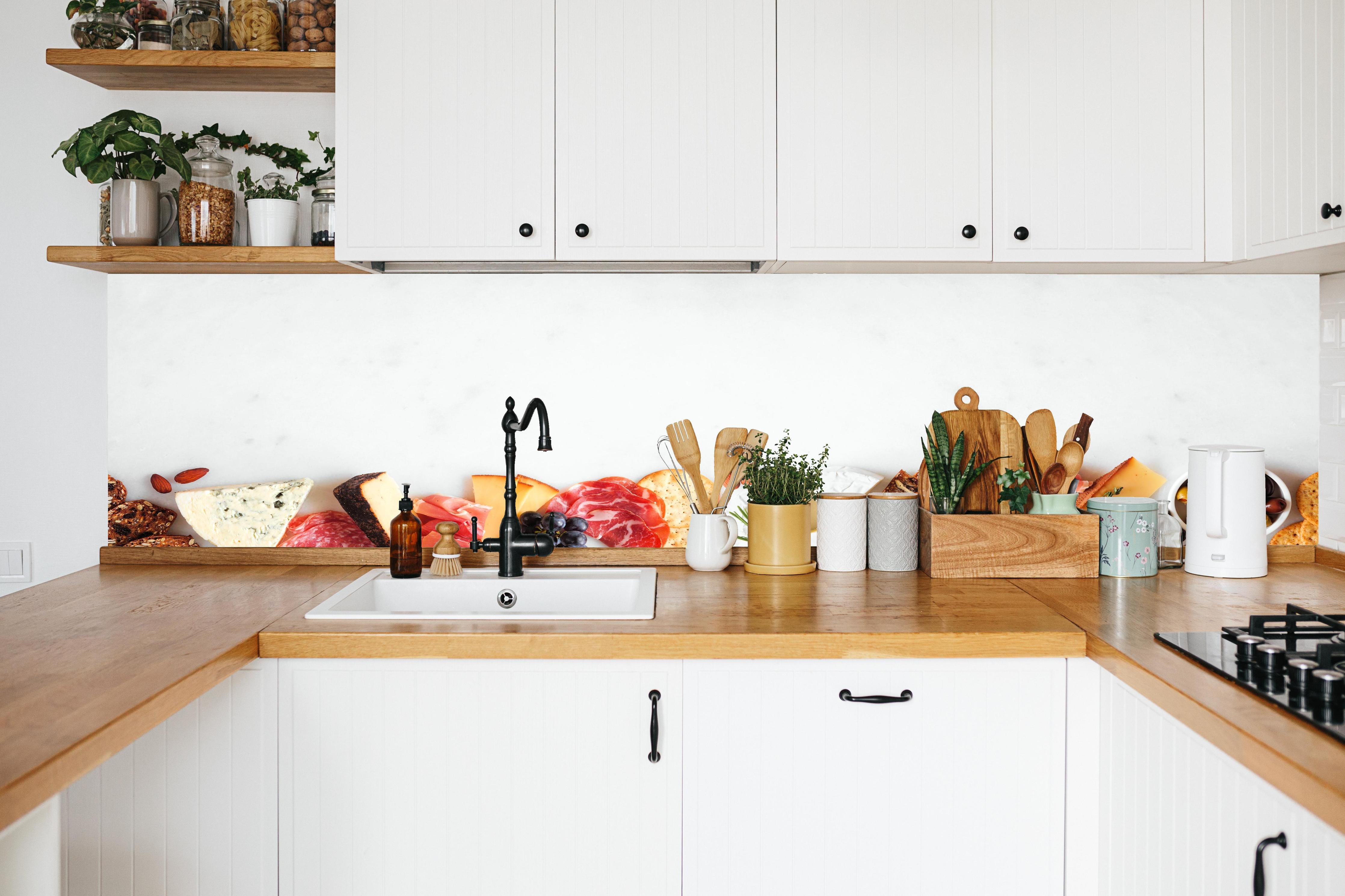 Küche - Käse und Antipasti auf Weiß in weißer Küche hinter Gewürzen und Kochlöffeln aus Holz