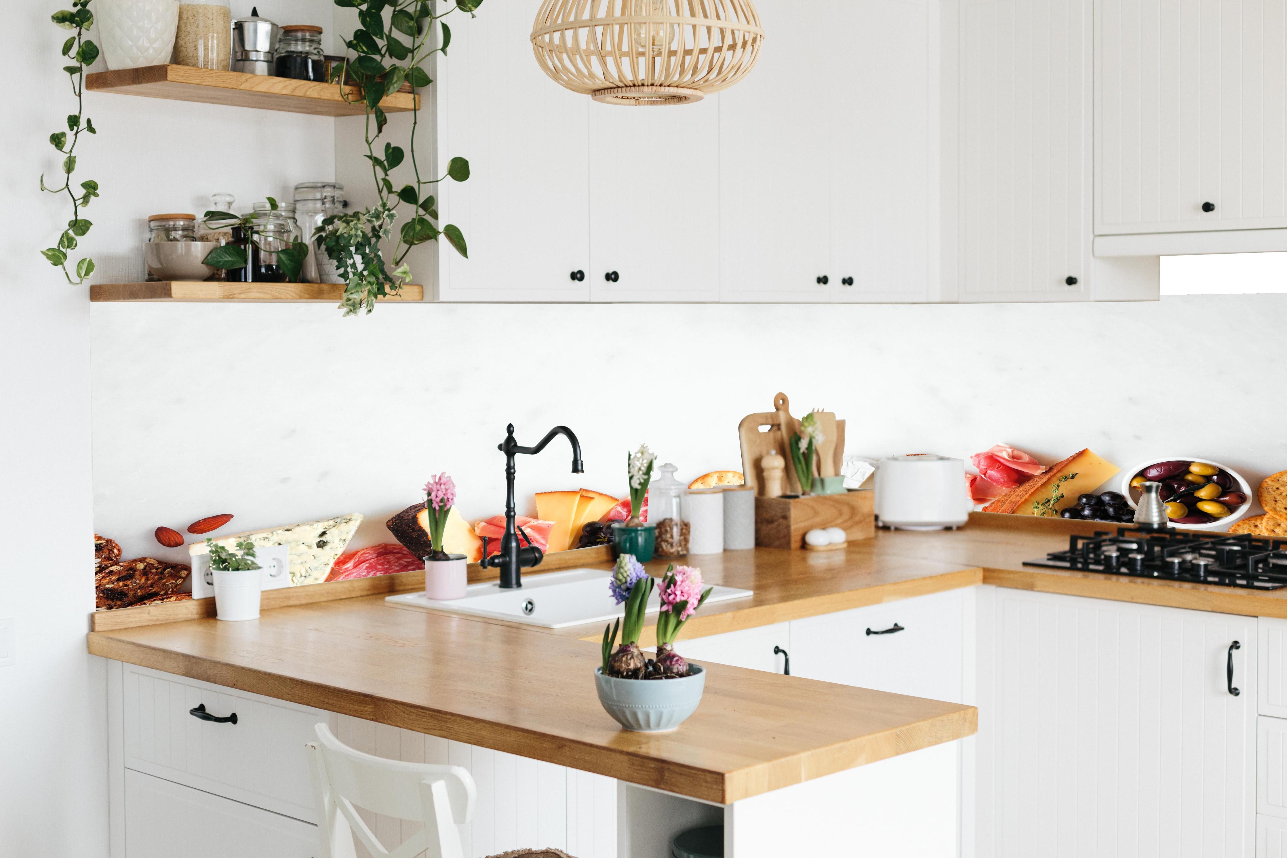 Küche - Käse und Antipasti auf Weiß in lebendiger Küche mit bunten Blumen