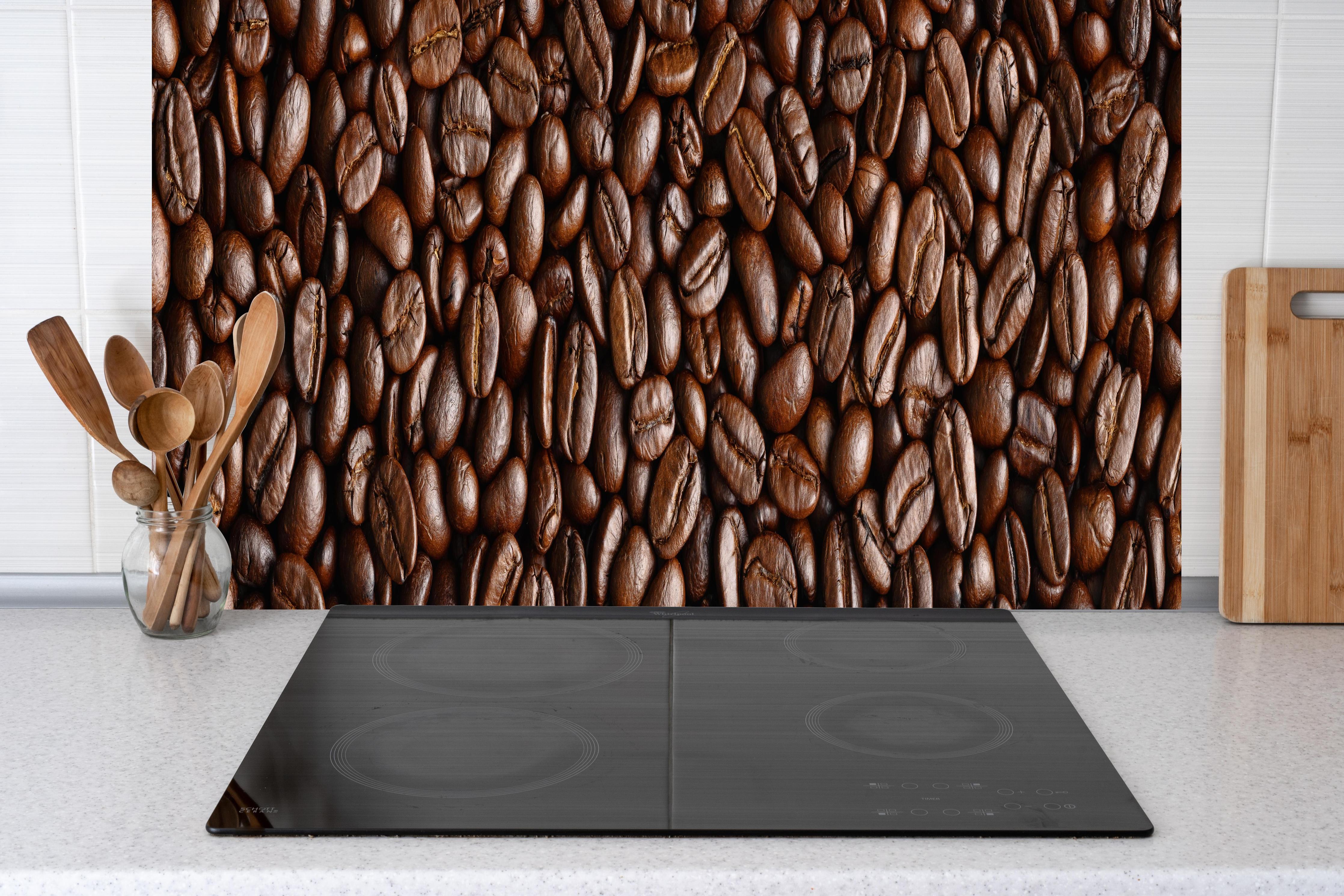 Küche - Kaffeebohnen Braun-Textur hinter Cerankochfeld und Holz-Kochutensilien