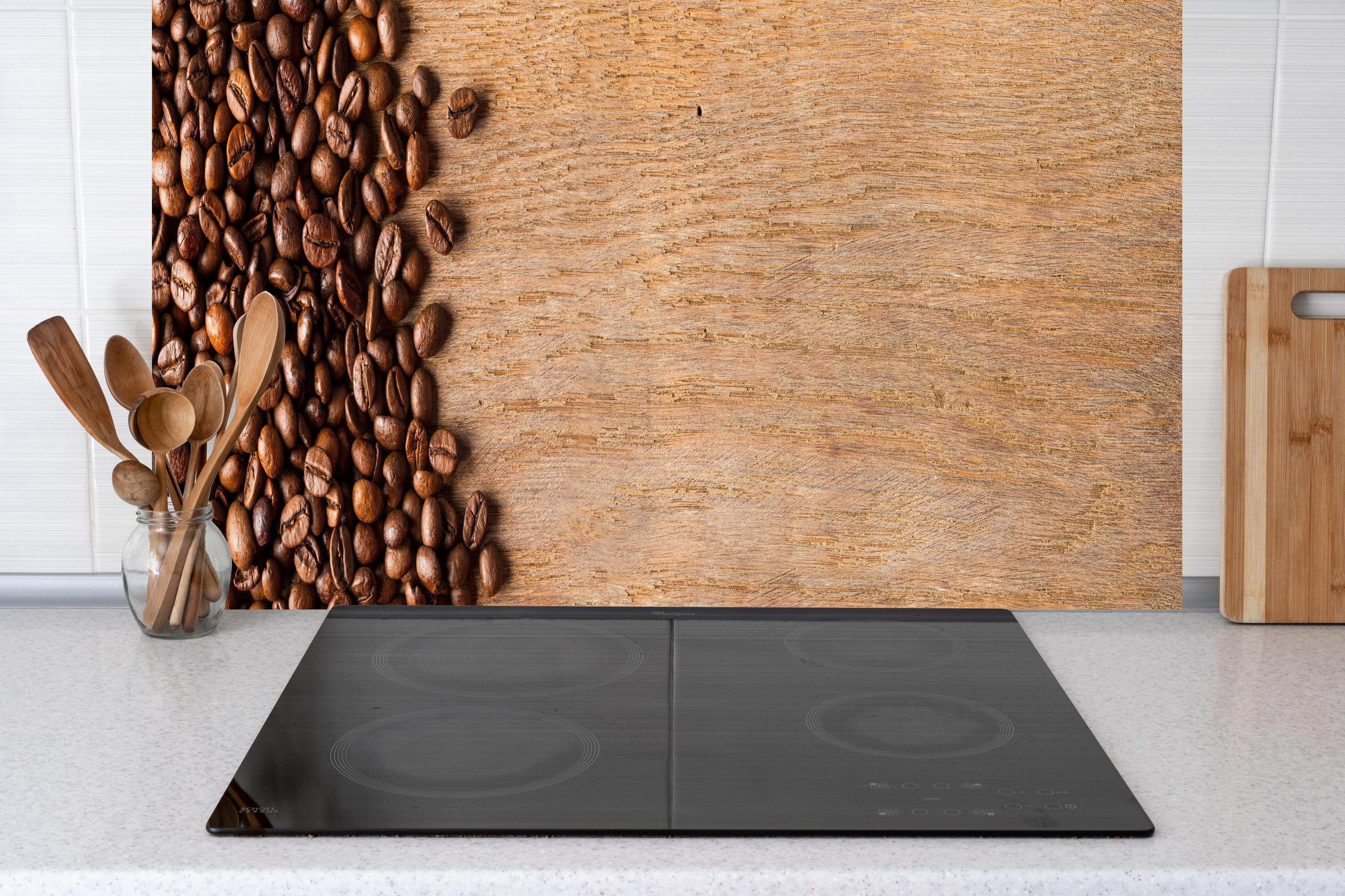 Küche - Kaffeebohnen auf Holz hinter Cerankochfeld und Holz-Kochutensilien