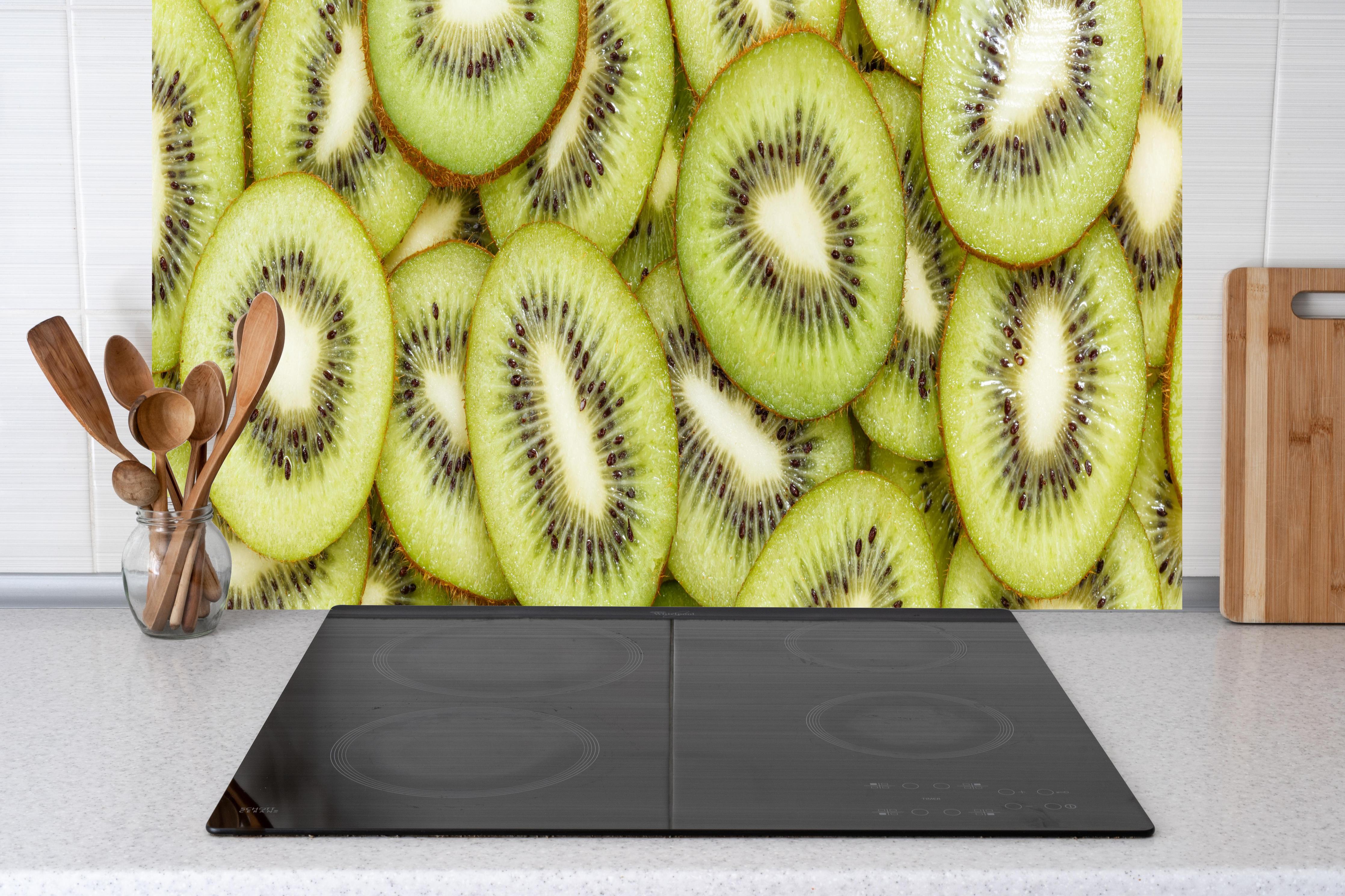 Küche - Kiwi-Scheiben Grün Fruchtmuster hinter Cerankochfeld und Holz-Kochutensilien