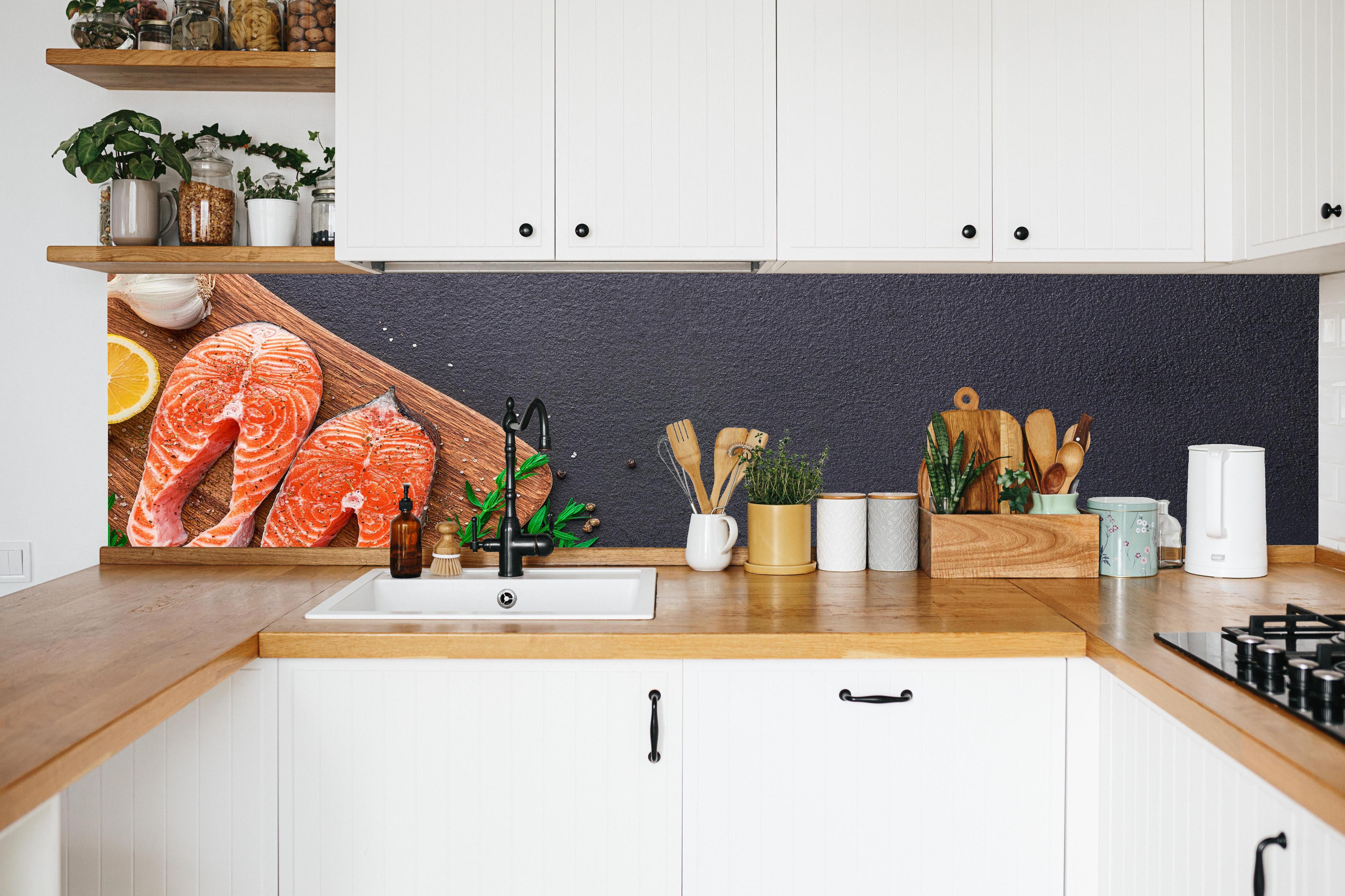 Küche - Lachssteaks auf Holzbrett in weißer Küche hinter Gewürzen und Kochlöffeln aus Holz