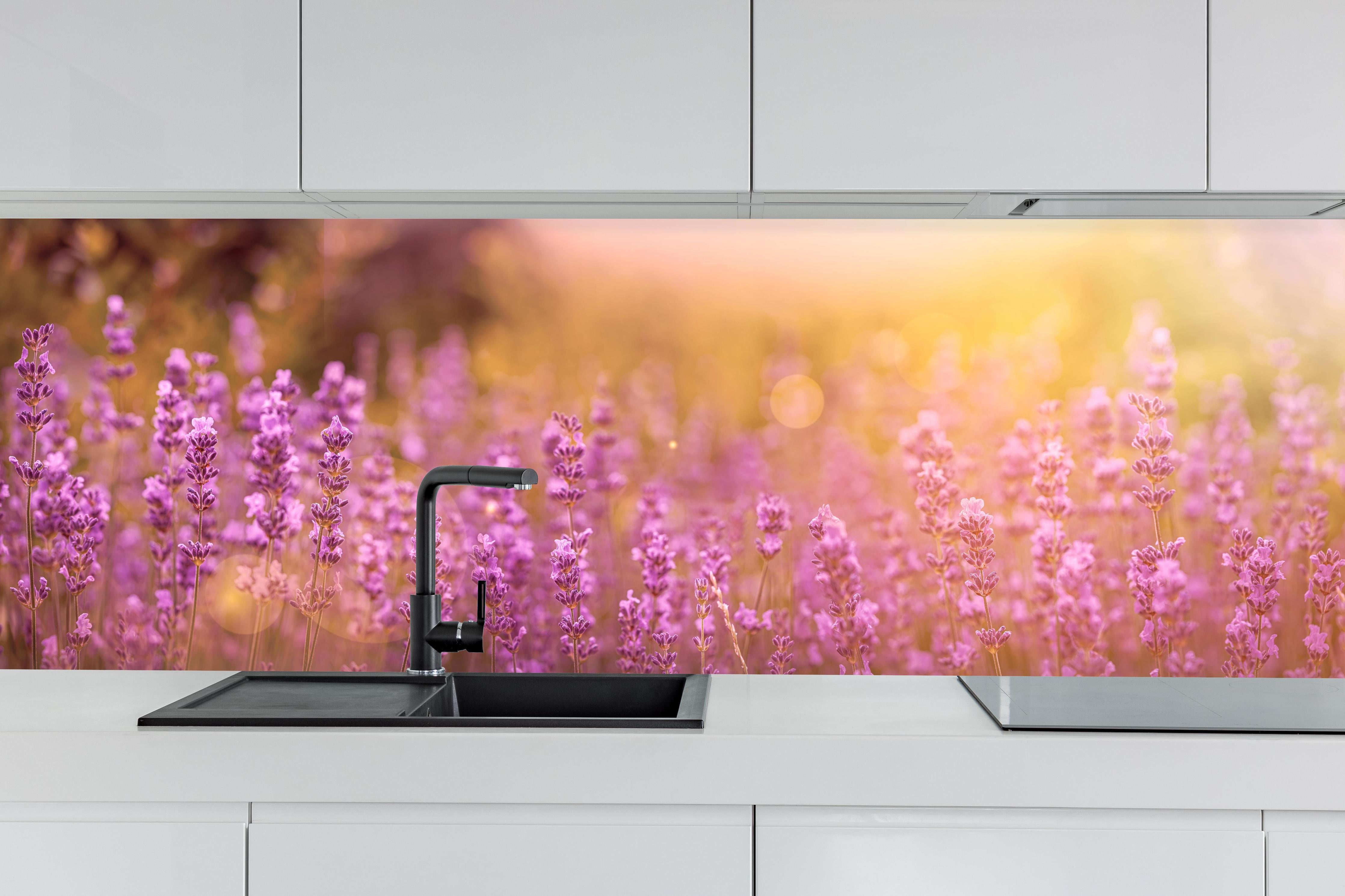 Küche - Lavendelfeld im warmen Abendlicht hinter weißen Hochglanz-Küchenregalen und schwarzem Wasserhahn