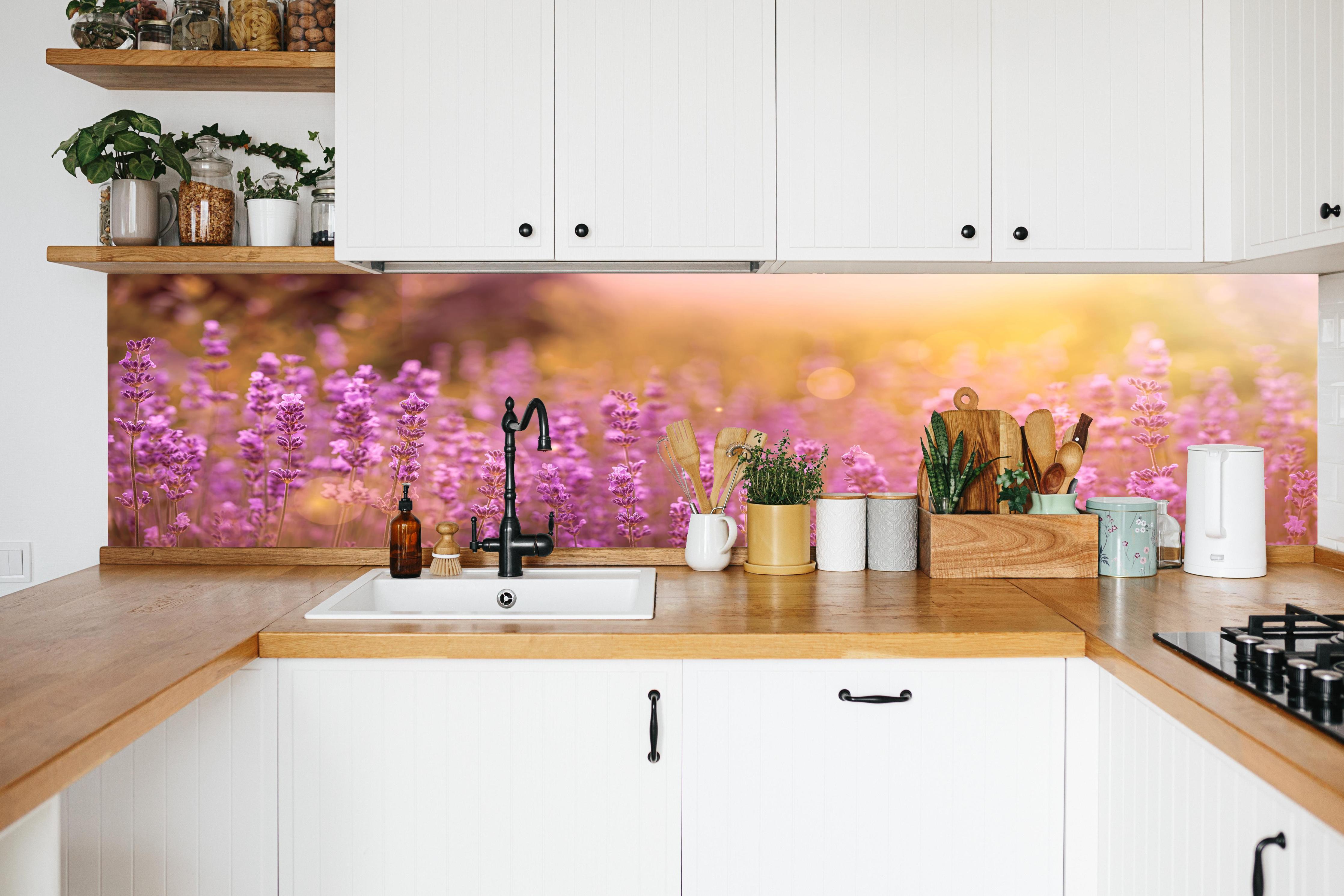 Küche - Lavendelfeld im warmen Abendlicht in weißer Küche hinter Gewürzen und Kochlöffeln aus Holz