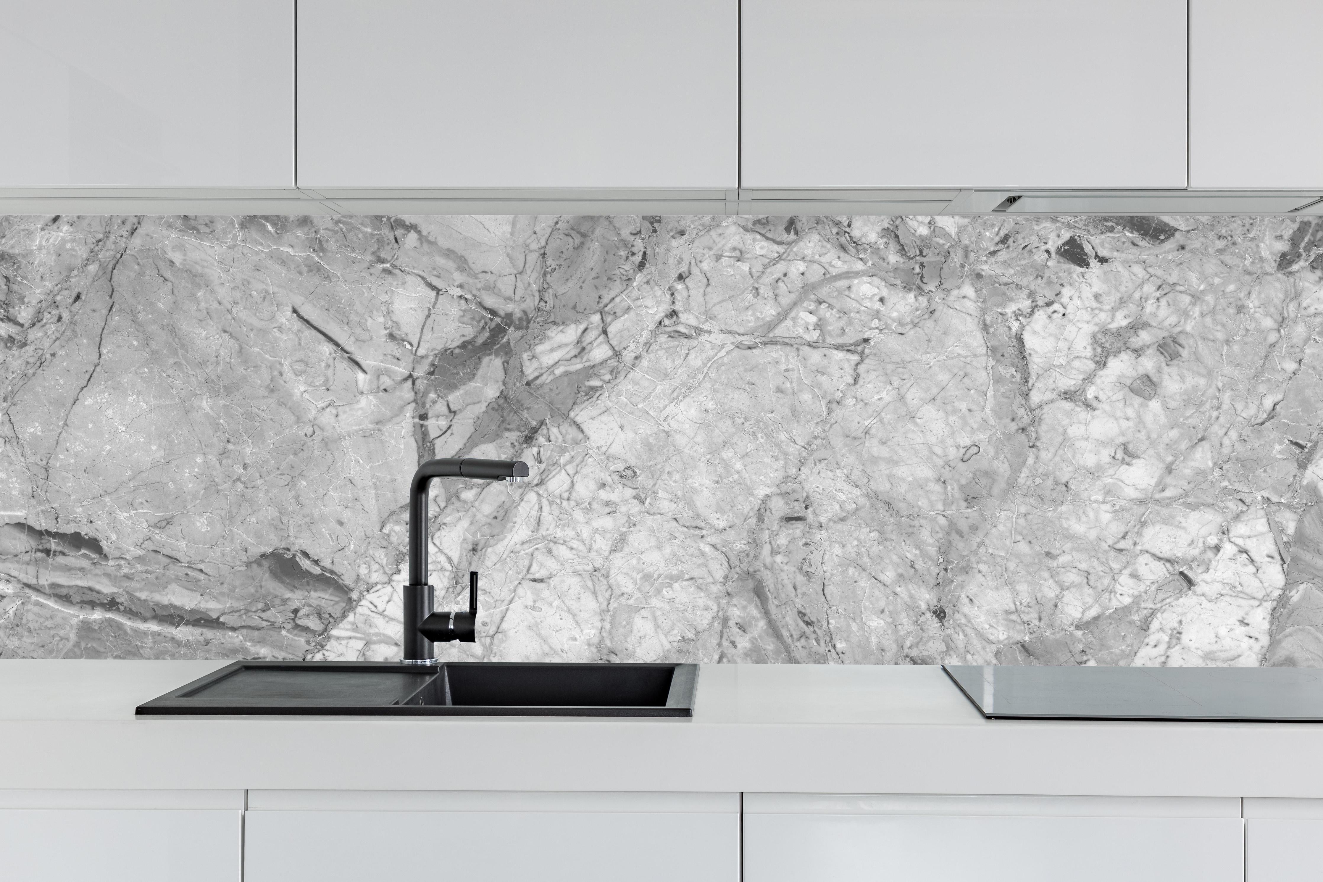 Küche - Luxuriöse Marmorstruktur in Weißgrau hinter weißen Hochglanz-Küchenregalen und schwarzem Wasserhahn