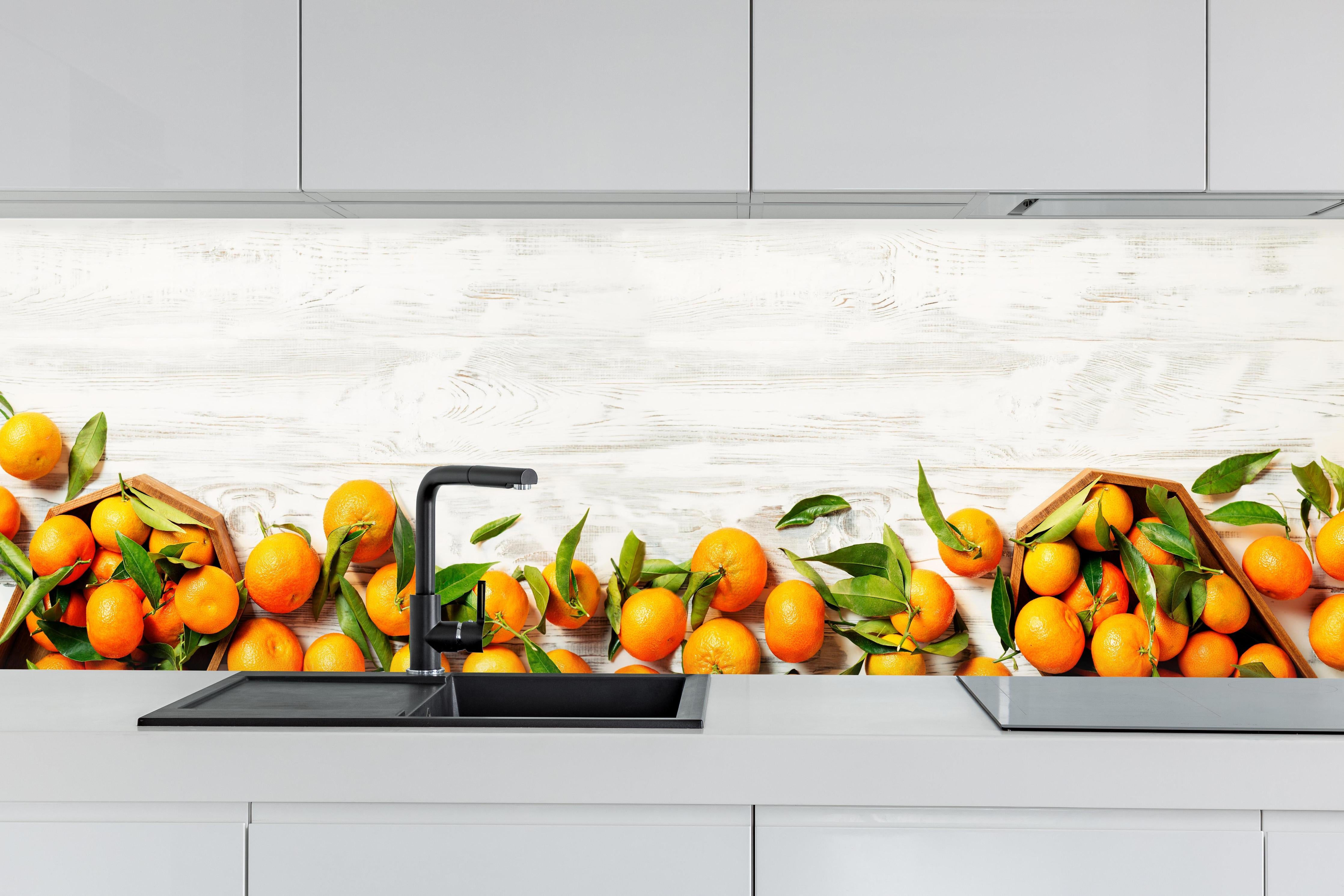 Küche - Mandarinen auf weißem Holz hinter weißen Hochglanz-Küchenregalen und schwarzem Wasserhahn