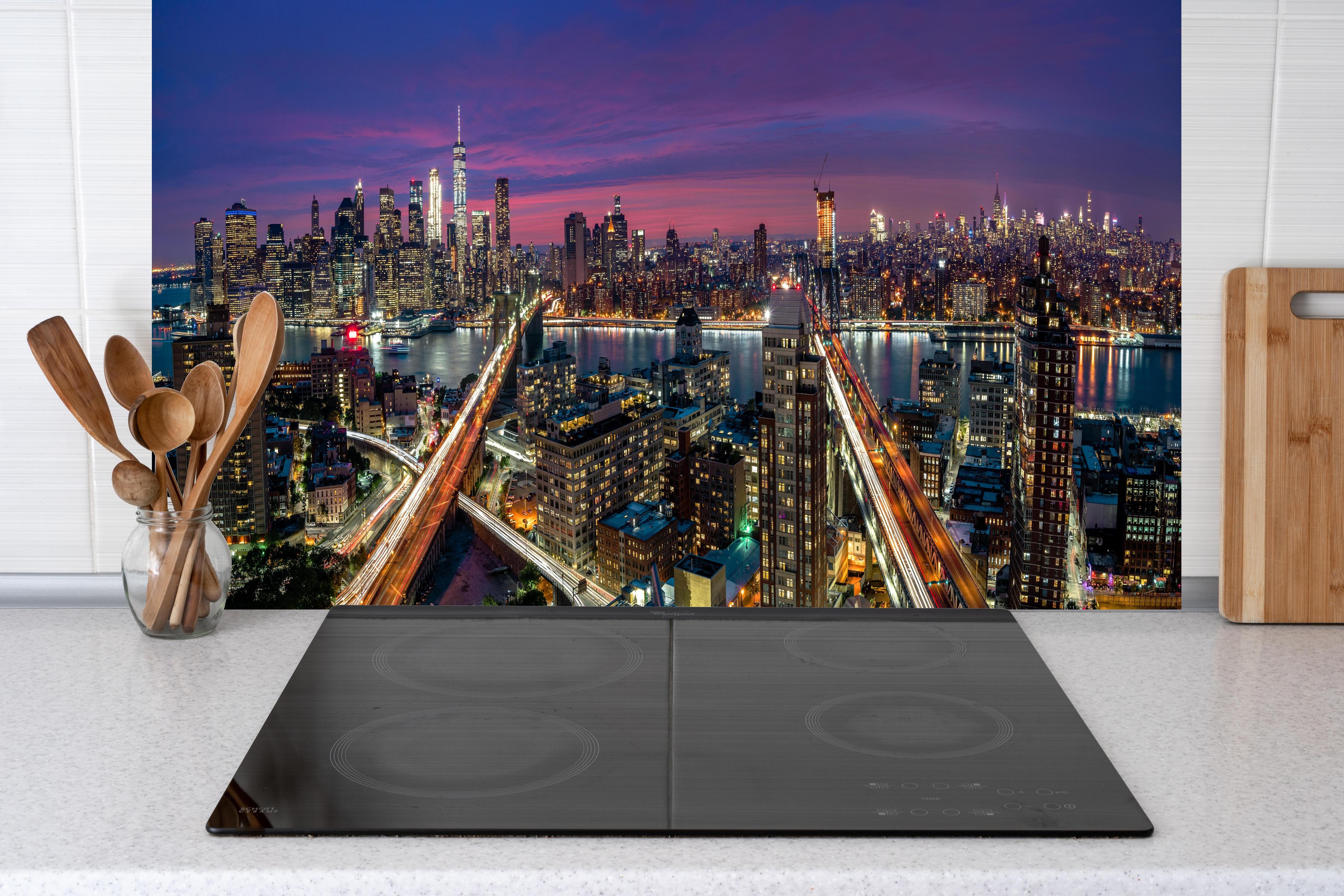Küche - Manhattan Skyline bei Dämmerung hinter Cerankochfeld und Holz-Kochutensilien