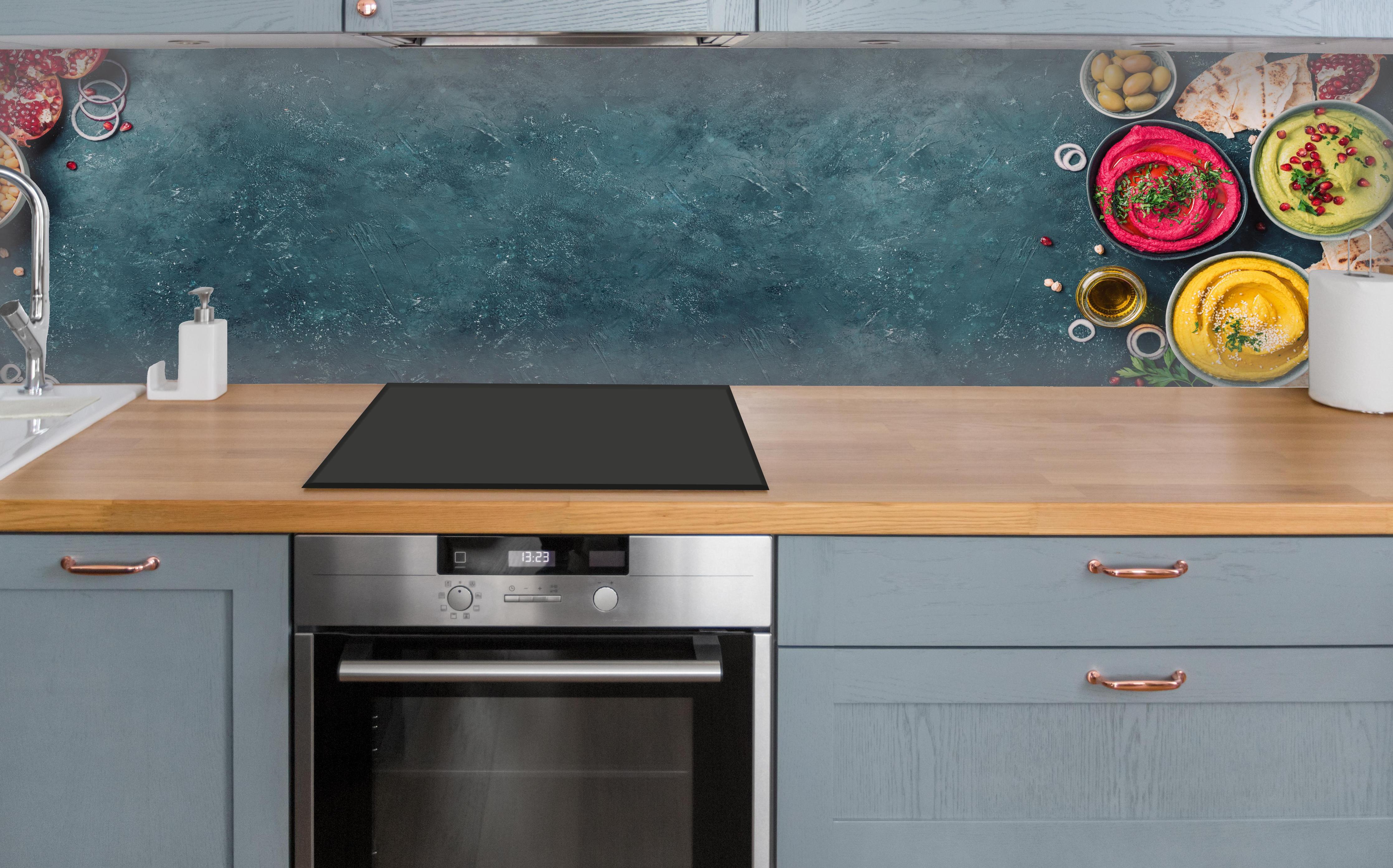 Küche - Mediterrane Gewürze und Oliven über polierter Holzarbeitsplatte mit Cerankochfeld