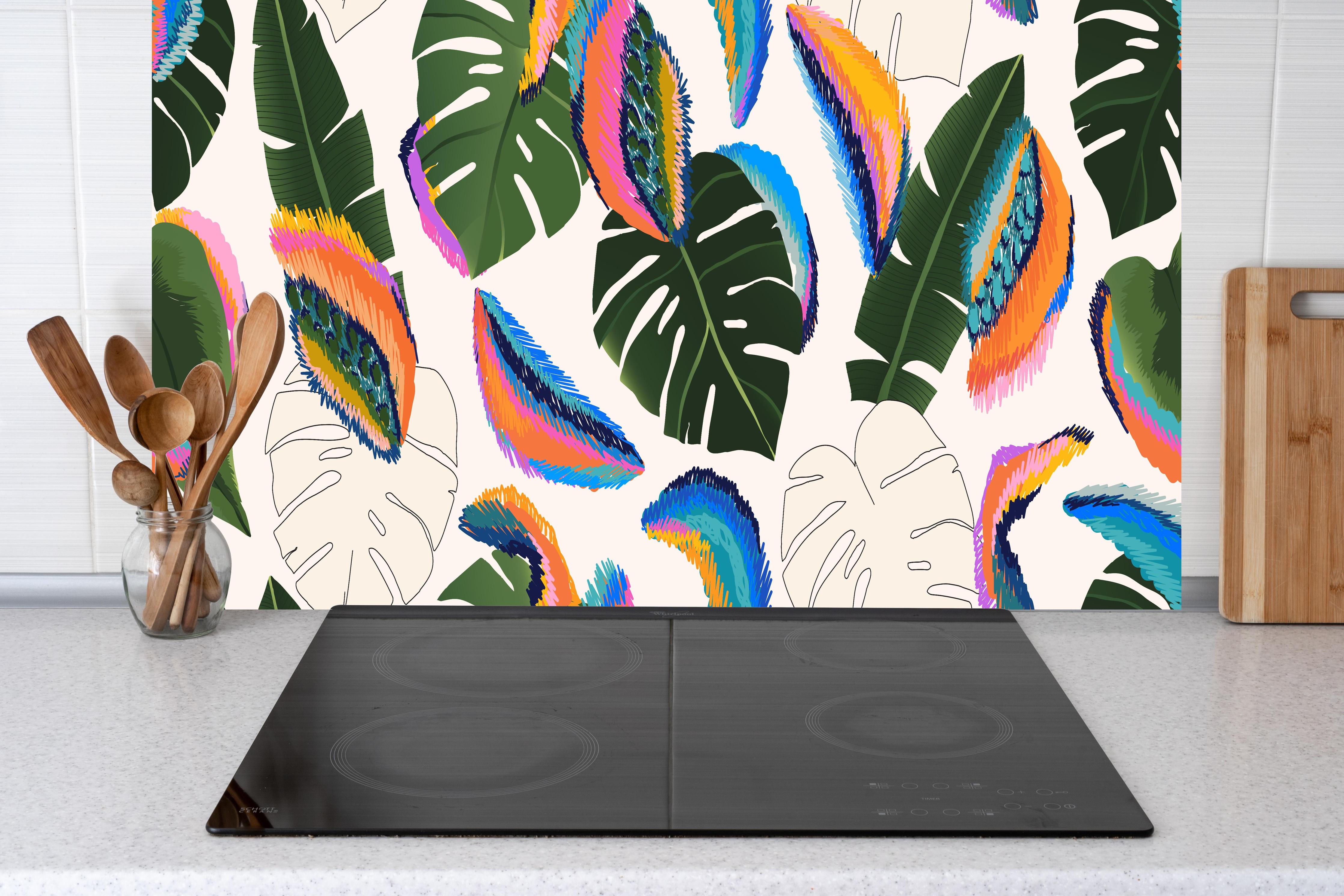 Küche - Monstera Tropic Bunte Blätter hinter Cerankochfeld und Holz-Kochutensilien