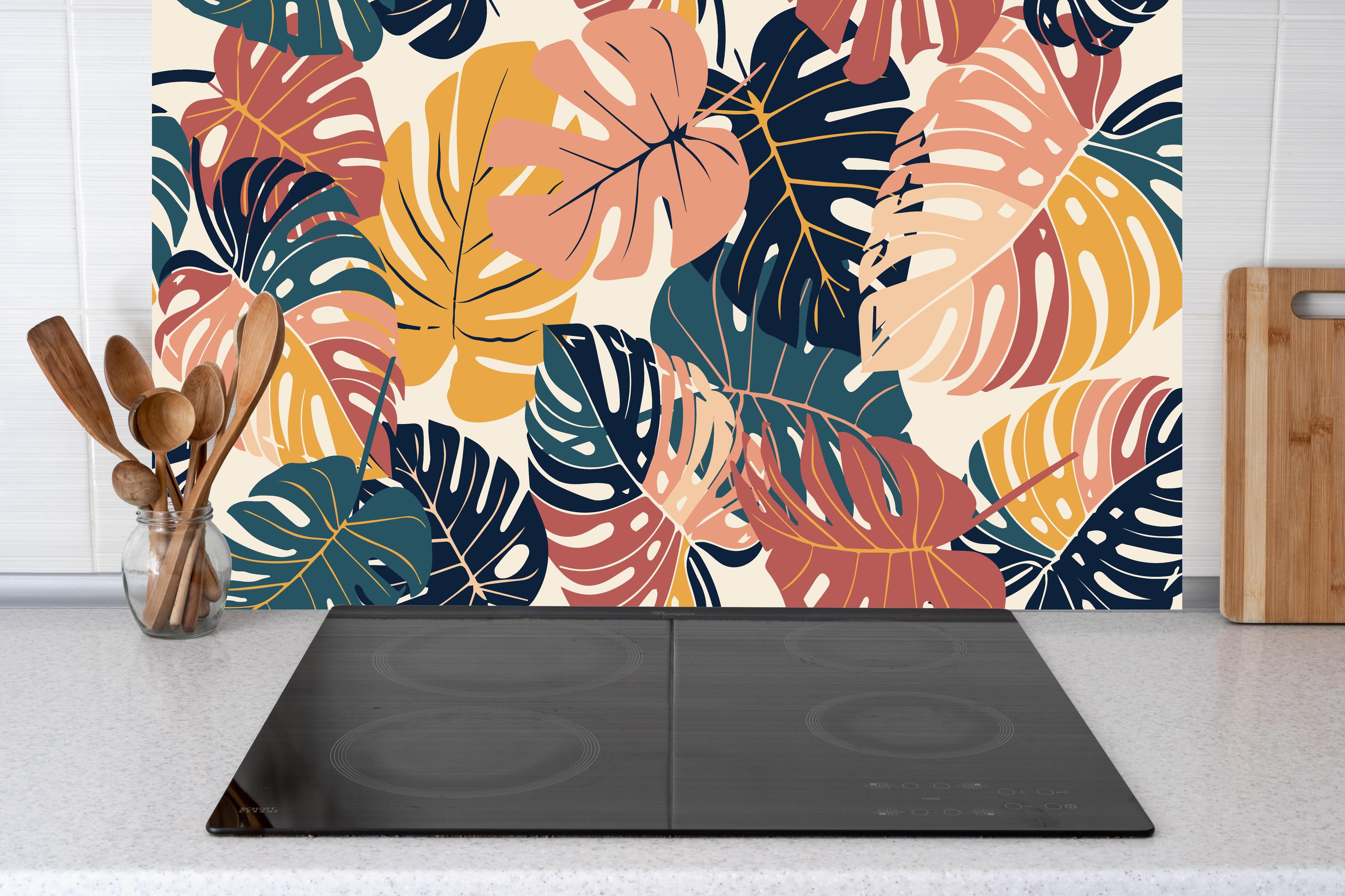 Küche - Monstera Tropic Koralle Türkis hinter Cerankochfeld und Holz-Kochutensilien