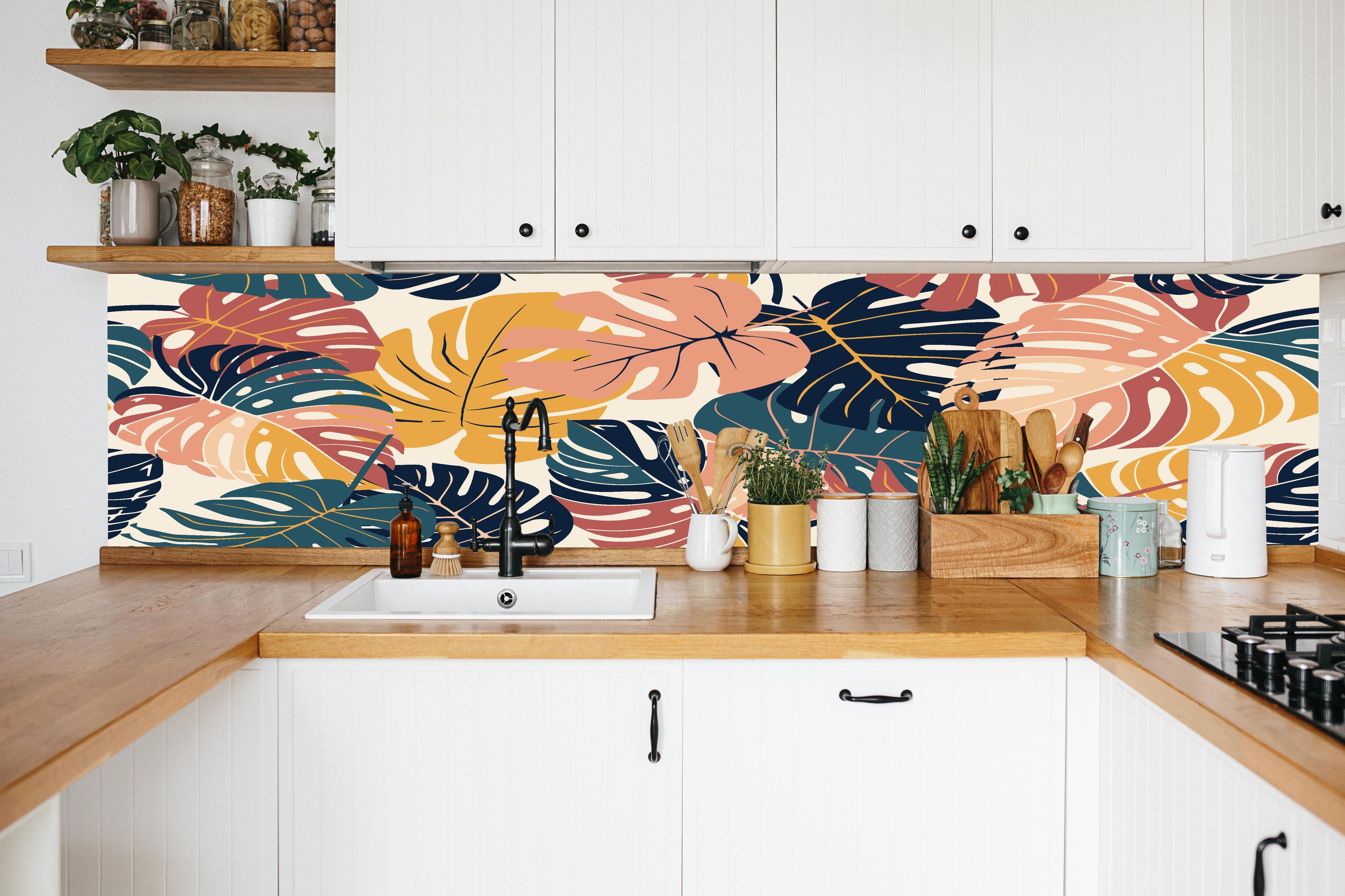 Küche - Monstera Tropic Koralle Türkis in weißer Küche hinter Gewürzen und Kochlöffeln aus Holz