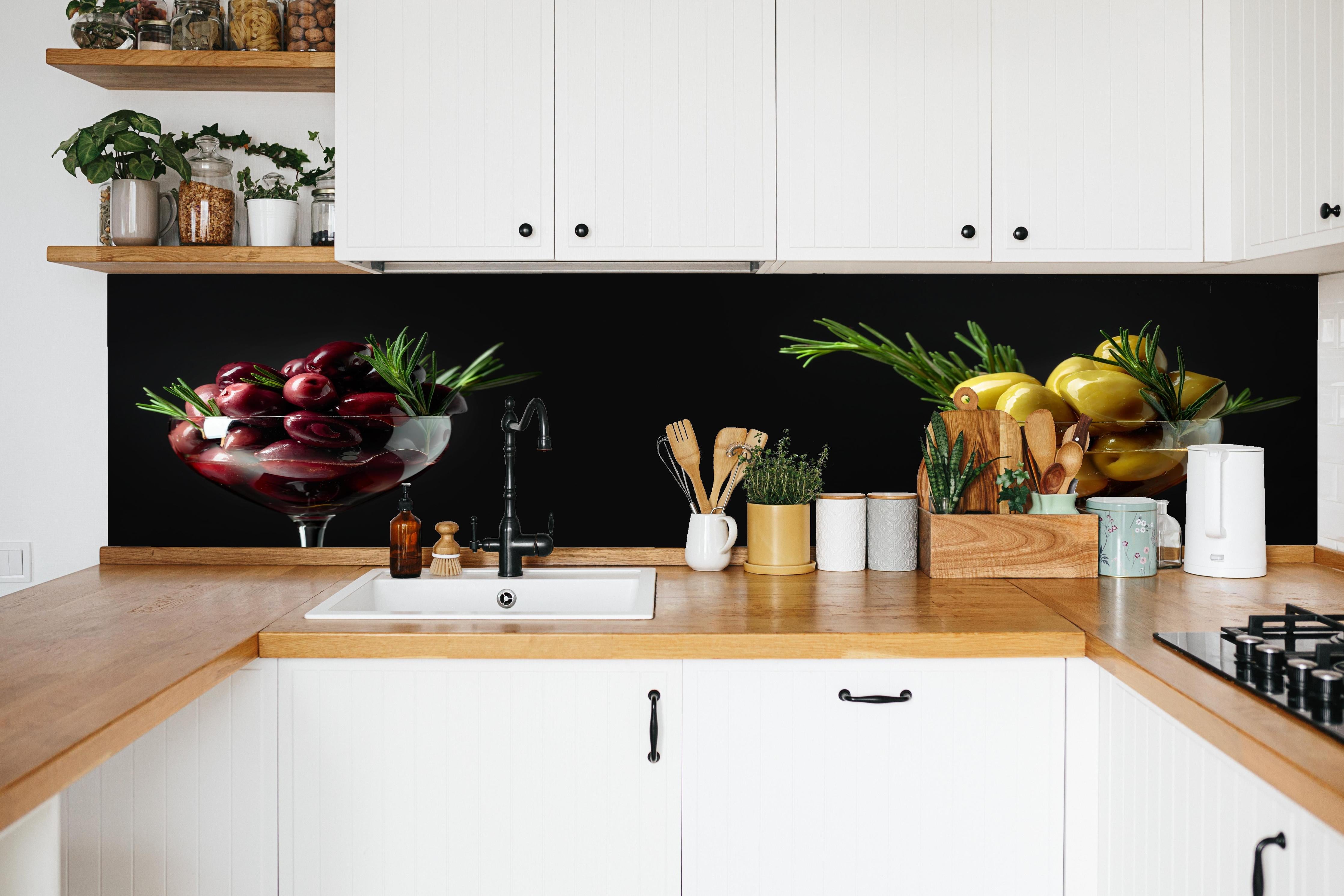 Küche - Oliven-Duo Rot und Gelb in weißer Küche hinter Gewürzen und Kochlöffeln aus Holz