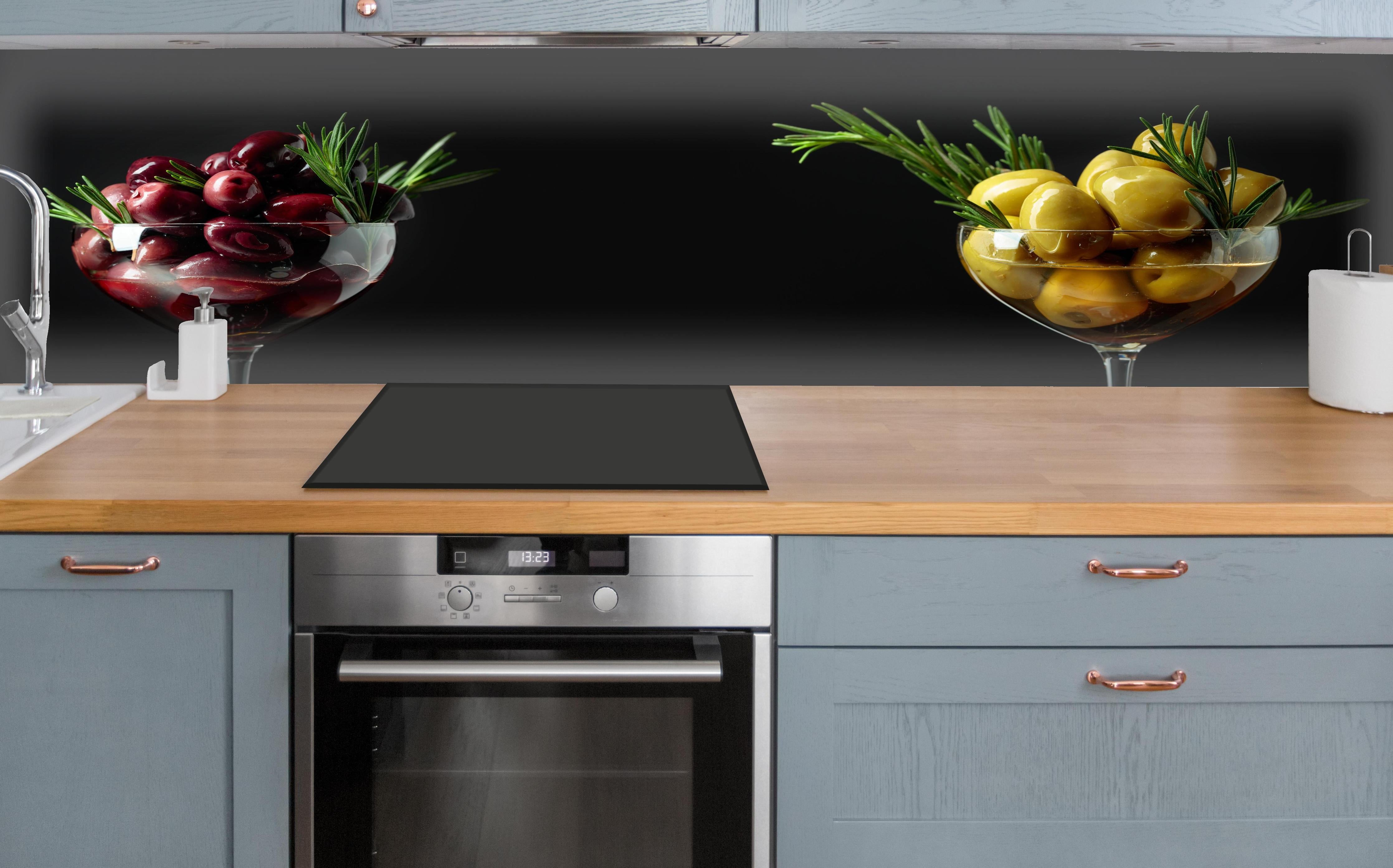 Küche - Oliven-Duo Rot und Gelb über polierter Holzarbeitsplatte mit Cerankochfeld