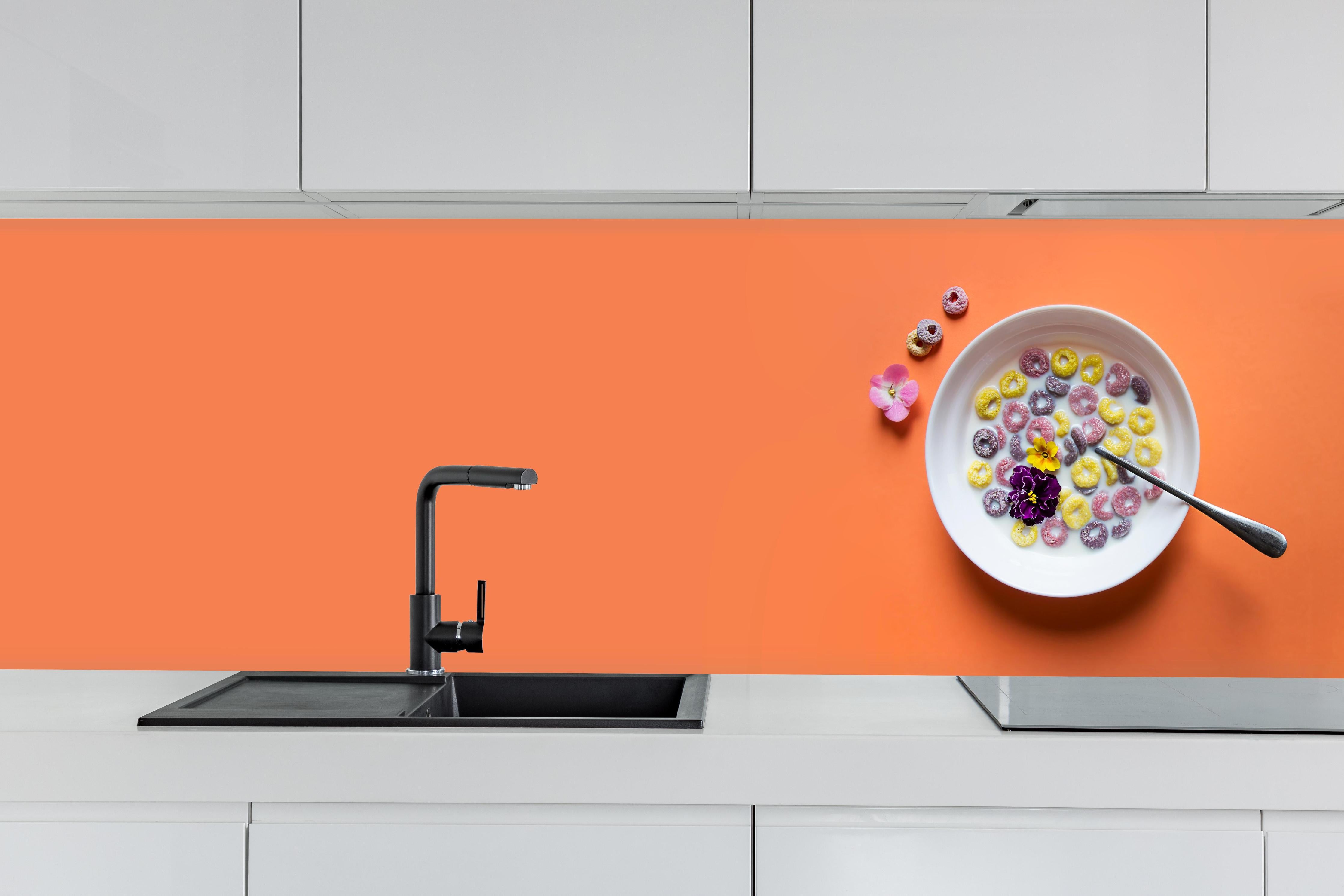 Küche - Orange Frühstücks-Bowl hinter weißen Hochglanz-Küchenregalen und schwarzem Wasserhahn