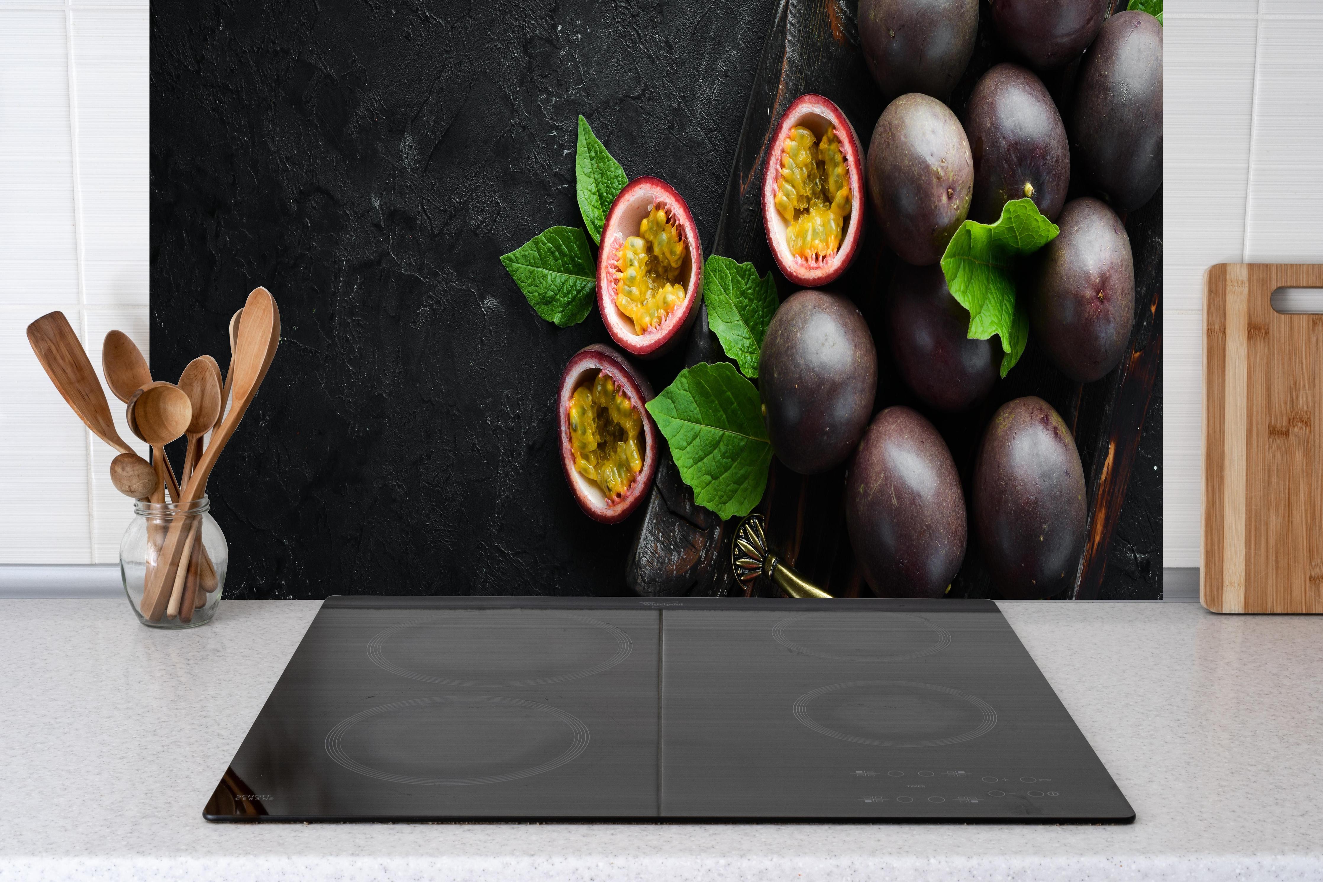 Küche - Passionsfrüchte Lila-Gelb-Grün hinter Cerankochfeld und Holz-Kochutensilien