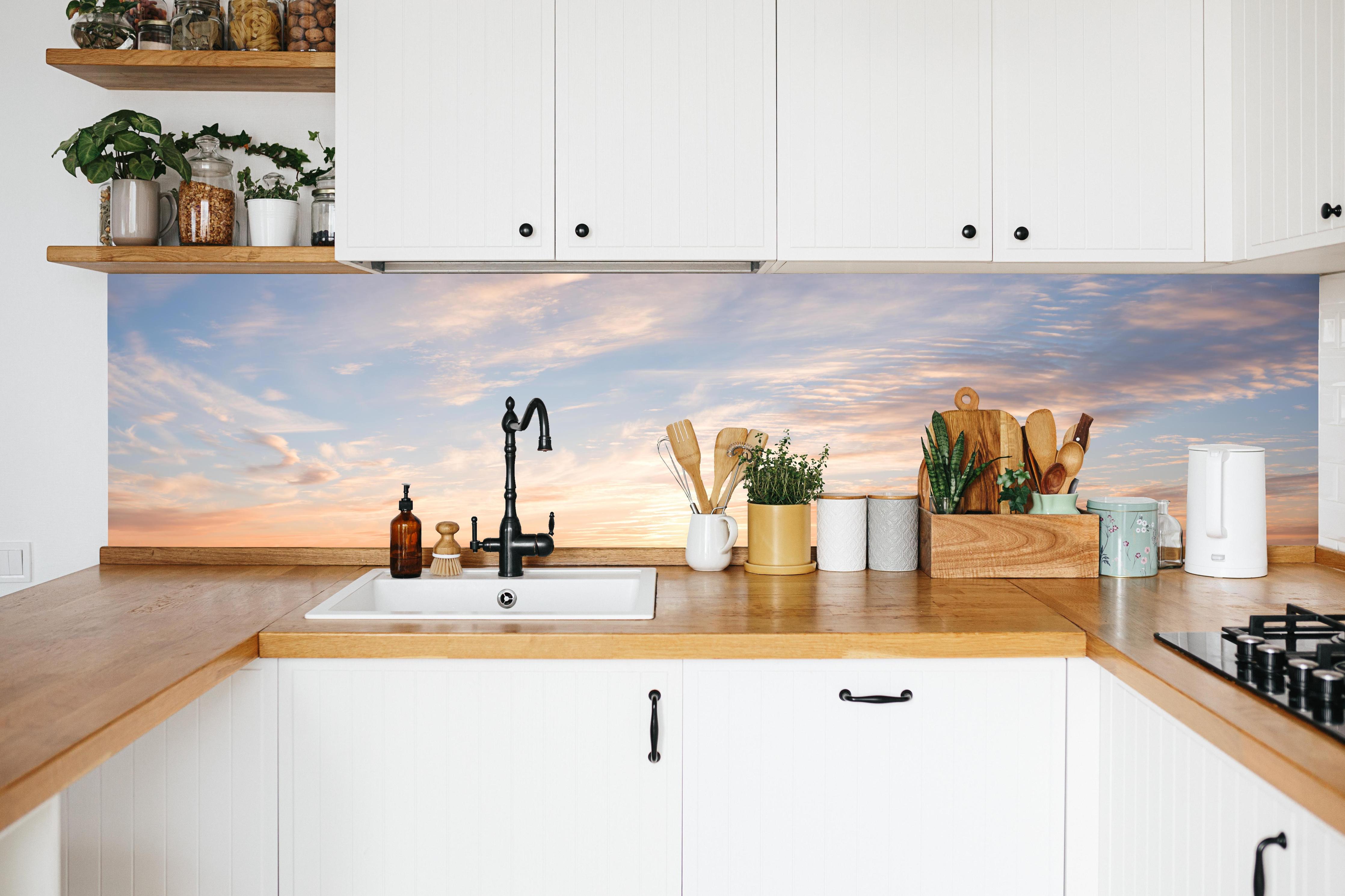 Küche - Pastellhimmel bei Sonnenuntergang in weißer Küche hinter Gewürzen und Kochlöffeln aus Holz
