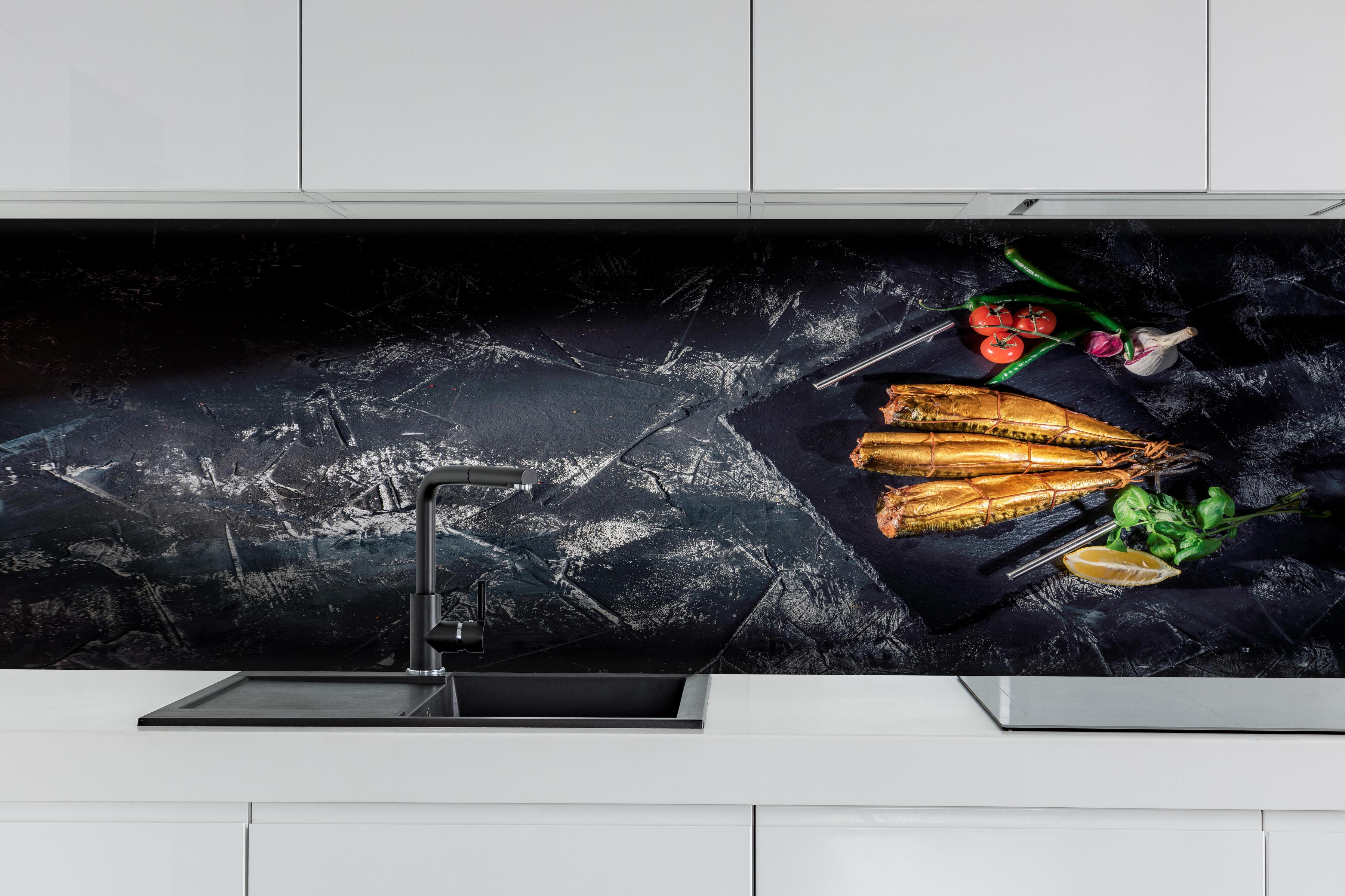 Küche - Räucherfisch auf dunklem Schiefer hinter weißen Hochglanz-Küchenregalen und schwarzem Wasserhahn