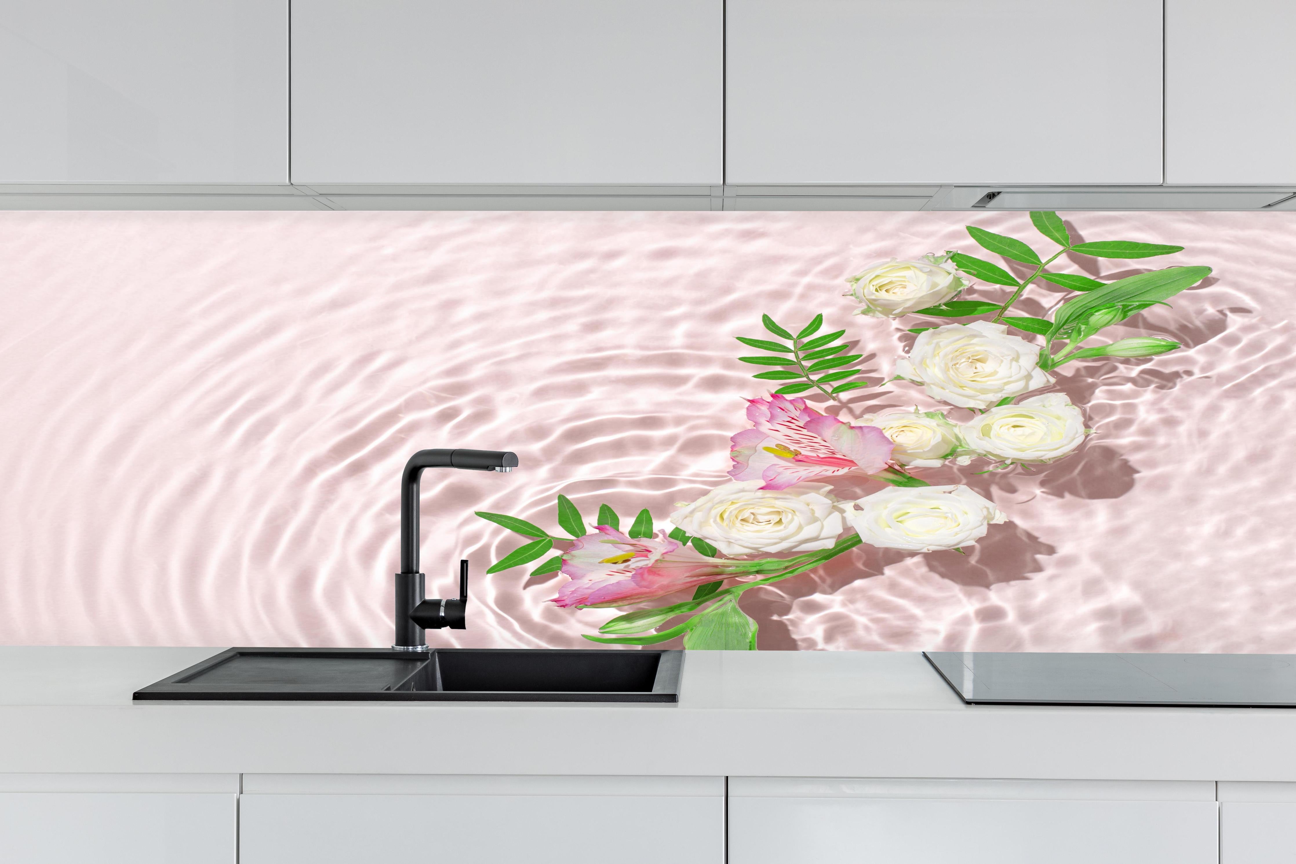 Küche - Rosa Blumen auf Wasser hinter weißen Hochglanz-Küchenregalen und schwarzem Wasserhahn