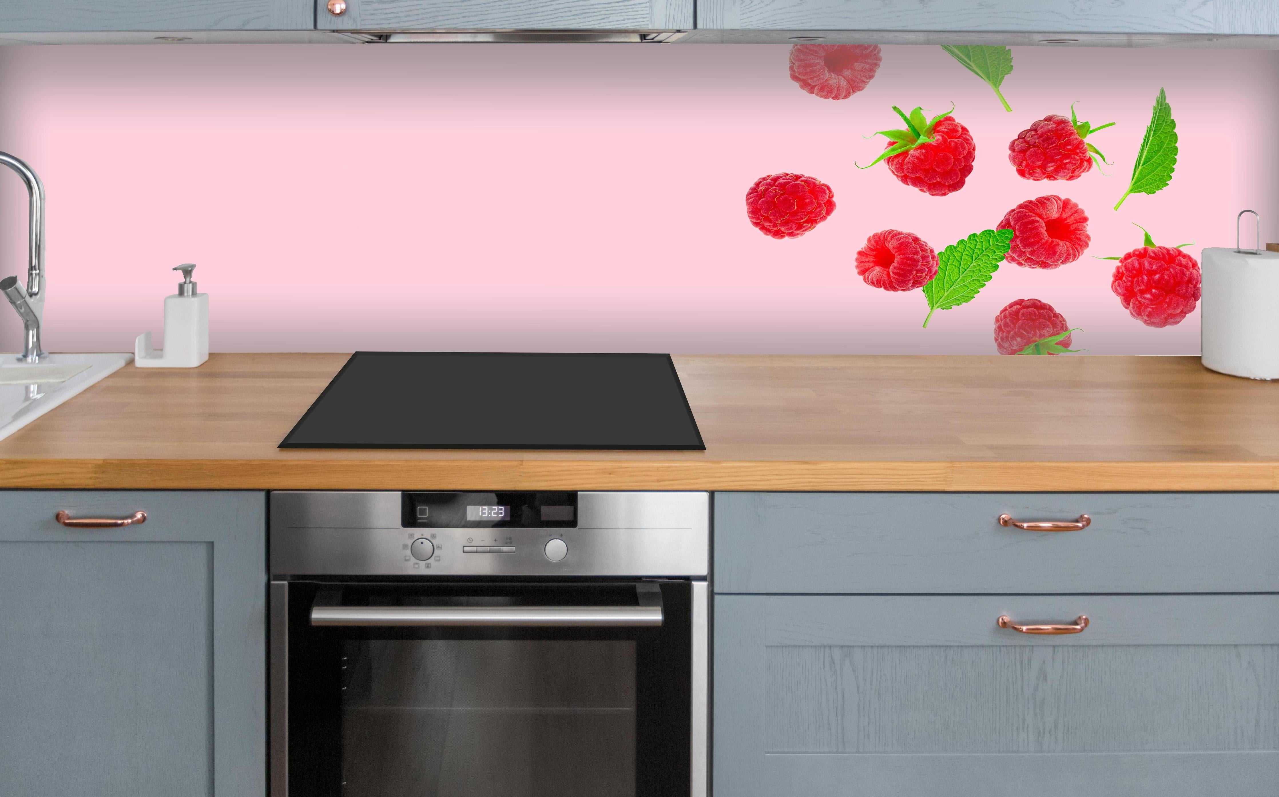 Küche - Rosa Himbeeren mit Minze über polierter Holzarbeitsplatte mit Cerankochfeld