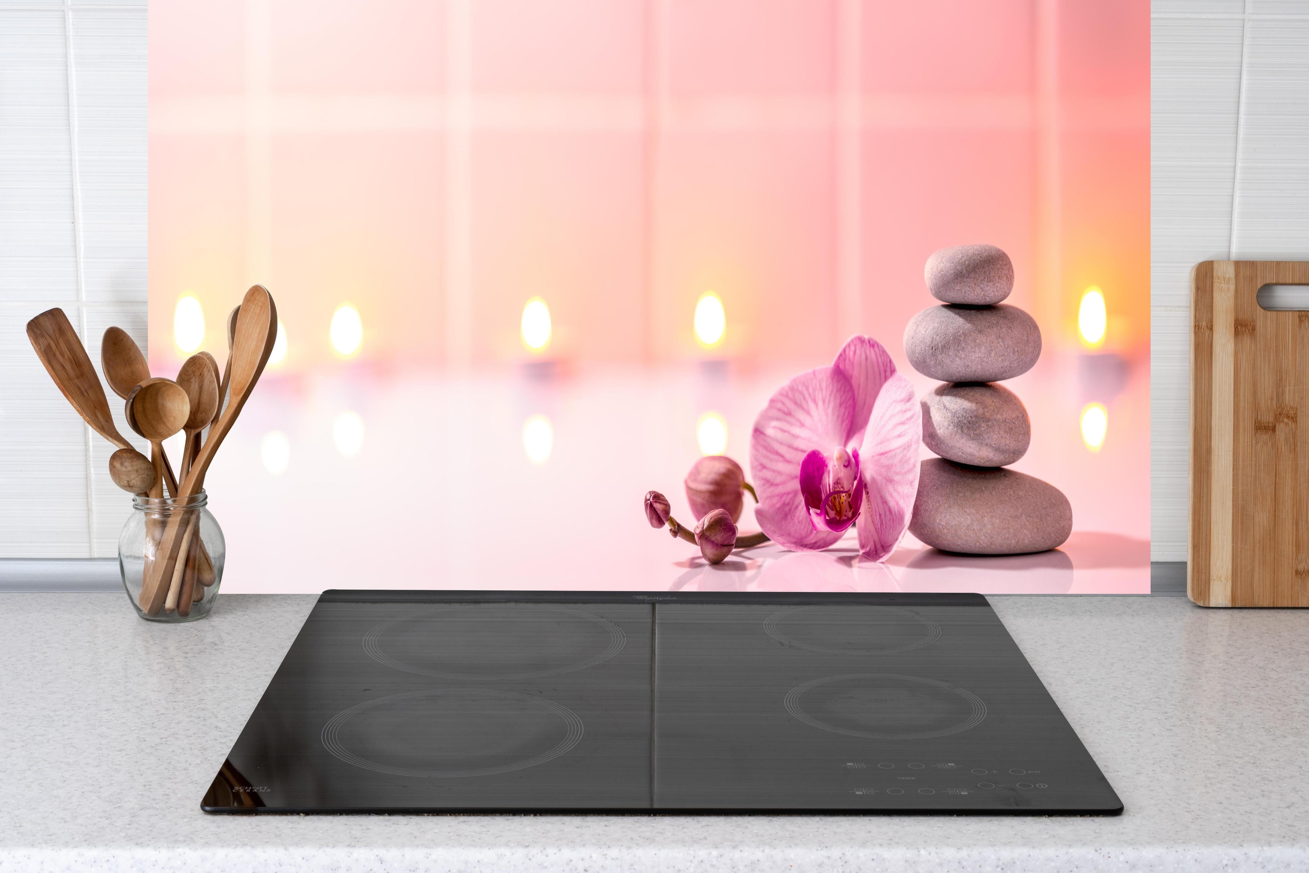 Küche - Rosa Orchidee mit Zen-Steinen hinter Cerankochfeld und Holz-Kochutensilien